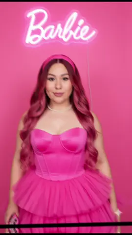 #geminiprompt #prompts #ai #barbie #create                        Perform based on my image without changing easy strokes or my face to a young woman with long balayage hair, with soft waves, posing in front of a bright pink background. His hair reaches his waist. On her head she wears a pink fabric headband to match her dress. Around her neck, she wears a white pearl necklace. The woman is dressed in a completely pink outfit. The dress has a corset design at the top, which highlights her figure. The talda is voluminous, with two layers of ruffles that give it a tutu appearance, She has soft makeup, with a faint pink lipstick that matches the pink of her outfit. His gaze goes directly to the camera. Behind her, there is a neon light that forms the word 