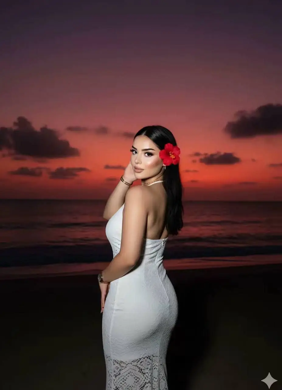 Make me look like I'm on a dark beach, but someone took a photo of me with a flash, and my face is a bit glowy. In the background, add a sunset. It looks like the sun has set 98% of the time, leaving a purple-red_ orange sky . The photo was taken from behind me, and I was asked to turn around for the photo. I'm wearing a beautiful, tight white dress, with a flower tucked into my hair. The photo was taken above the waist, so it only shows my upper body.#الذكاء_الاصطناعي #ترند #gemini #تيك_توك #صورتك 