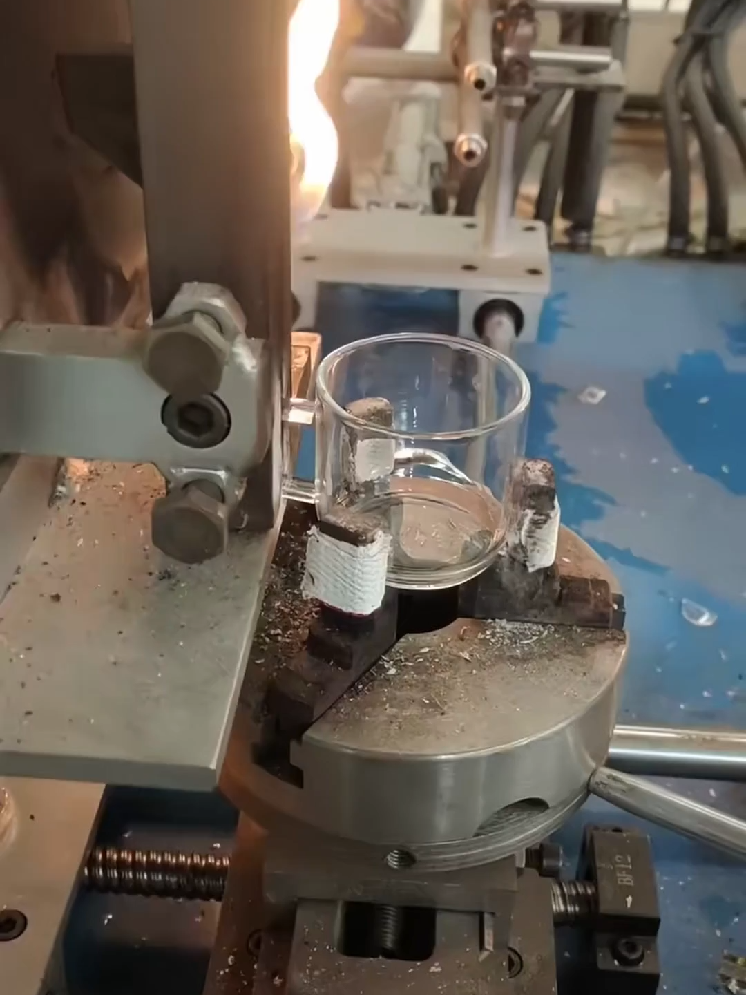 Hot-joining a handle to a glass cup.