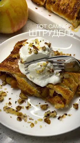 🍏ЛЕНИВЫЙ ШТРУДЕЛЬ, от которого невозможно отказаться Только представьте: хрустящее тесто, из которого слегка вытекает ароматная начинка из карамельных яблок и груш… а рядом тает шарик мороженого, посыпанный хрустящими орешками….Это нереально вкусно🤤🤤🤤Обязательно попробуйте.! ✨Понадобится: Слоеное тесто бездрожжевое – 250 г 🍏Для начинки:  Яблоки и груши – 3-4 шт. Масло сливочное – 30 г Сахар коричневый – 20 г Корица – 1-2 ч. л. (по вкусу) Крахмал – 1 ч. л.  Желток – 1 шт (для смазывания) 🍨Для подачи: ванильное мороженое и грецкие орехи 🥣Приготовление: 1.  Замороженное слоеное тесто достаньте за 1-1,5 ч до приготовления из морозилки (оставьте при комнатной температуре, накройте полотенцем или пленкой, чтобы края теста не подсохли). 2.  В это время для начинки: фрукты нарежьте кубиками и обжарьте на сливочном масле с коричневым сахаром и корицей до мягкости. Чтобы начинка была стабильной, добавьте 1 ч. л. крахмала, разведенную в 1 ст. л. воды, и прогрейте до загустения, постоянно помешивая.   3.  Раскатайте тесто в прямоугольник. С двух сторон сделайте надрезы, как на «косичку».  4.  Выложите начинку в центр, аккуратно сверните края теста «косичкой». Смажьте желтком и для хруста посыпьте сахаром.  5.  Выпекайте в разогретой духовке до 180°С 30-35 мин (режим «верх-низ» с конвекцией) до румяной хрустящей корочки. Подавайте теплым, с шариком пломбира и дроблёными орешками. Это безумно вкусно🤤 Если вы любите простую и очень вкусную выпечку – подписывайтесь. В актуальных ждет более 💯проверенных рецептов на все случаи.  💌Обязательно сохраните рецепт. Вам точно захочется его повторить. Готовьте с удовольствием. #штрудель #ленивыйштрудель #выпечкасяблоками #выпечка #фудблог 