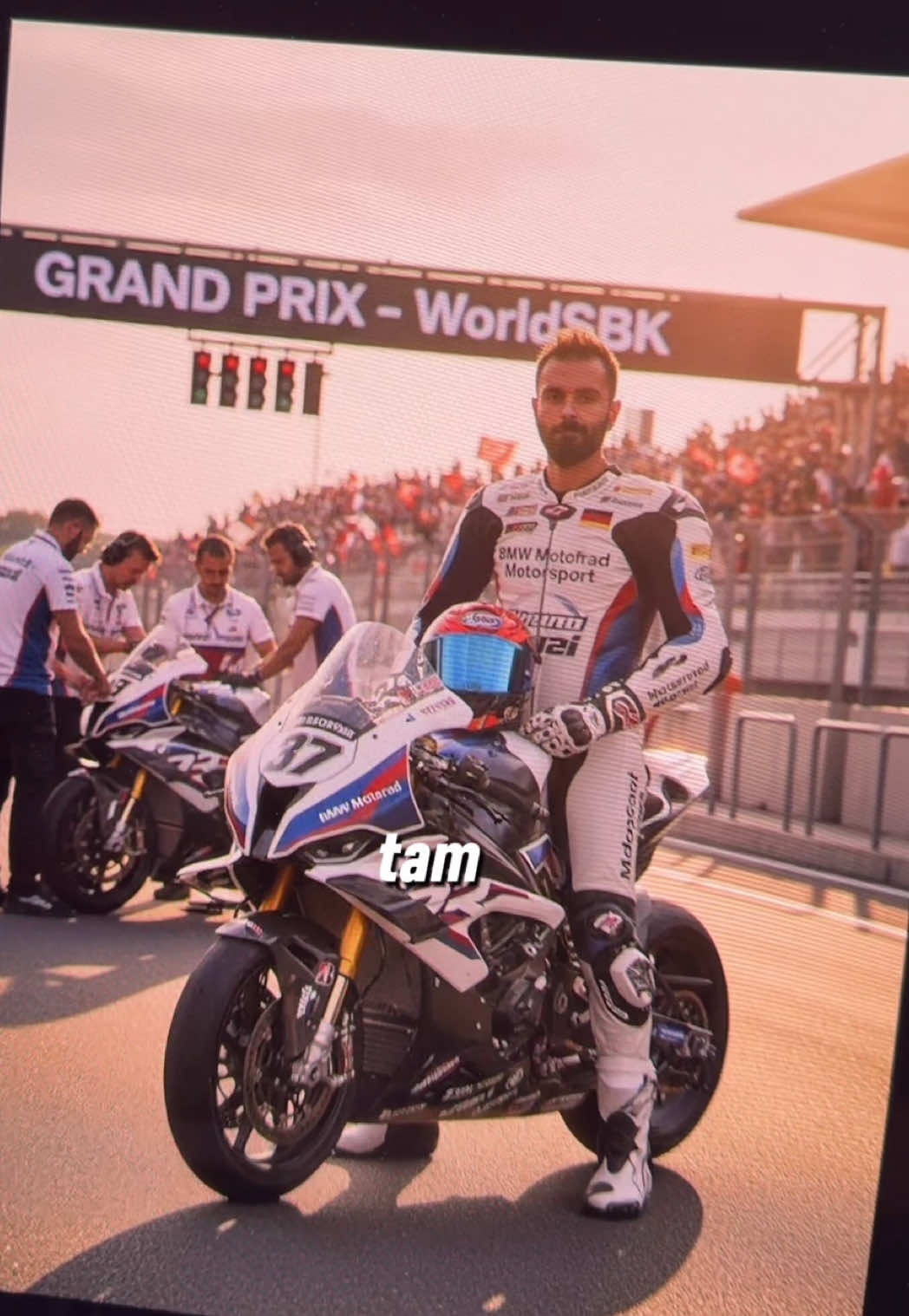 Toprak Razgatlıoğlu gibi bir fotomuz olmasın mı 🇹🇷🇹🇷 Reklam Prompt: An ultra-realistic photo of the WorldSBK scene at the Mandalika International Circuit. A young racer [see attached photo, face and hair must remain 100% accurate] stands confidently next to his BMW M 1000 RR number 37. He wears a BMW Motorrad Motorsport racing suit in white, blue, and red colors with sponsor logos and a small German flag patch on the chest. In his right hand, he holds a BMW Motorrad helmet with a metallic blue visor, while the details of his gloves and boots are clearly visible with a leather and carbon-fiber texture. Motorcycle: The BMW M 1000 RR features BMW’s signature white, blue, and red (Motorsport) livery, with aerodynamic fairings bearing large BMW Motorrad Motorsport logos on both sides. The bike includes carbon wheels, Pirelli slick tires, a titanium Akrapovič exhaust, and a gold Öhlins front suspension, all shining under the sunset light with futuristic aerodynamic winglets. Background: The stands are filled with cheering spectators waving BMW Motorsport and Turkiye flags. A large LED screen displays “GRAND PRIX – WorldSBK.” Behind the racer, BMW pit crew members in official uniforms are seen making last-minute adjustments and checking telemetry data. Ambiance: Cinematic and powerful — golden hour sunlight hits the track, casting reflections on the fairings and visor surfaces. Light dust and subtle reflections on the asphalt create a heroic, high-performance atmosphere just before the race starts. Style: Ultra-realistic 8K resolution, cinematic lighting, crisp focus, with a visual aesthetic inspired by official BMW Motorrad Motorsport campaign posters — emphasizing precision, performance, and engineering excellence, with tones of pearl white, deep blue, and metallic red. . . . #gemini #nanobanana #prompt #toprakrazgatlıoğlu #motogp      