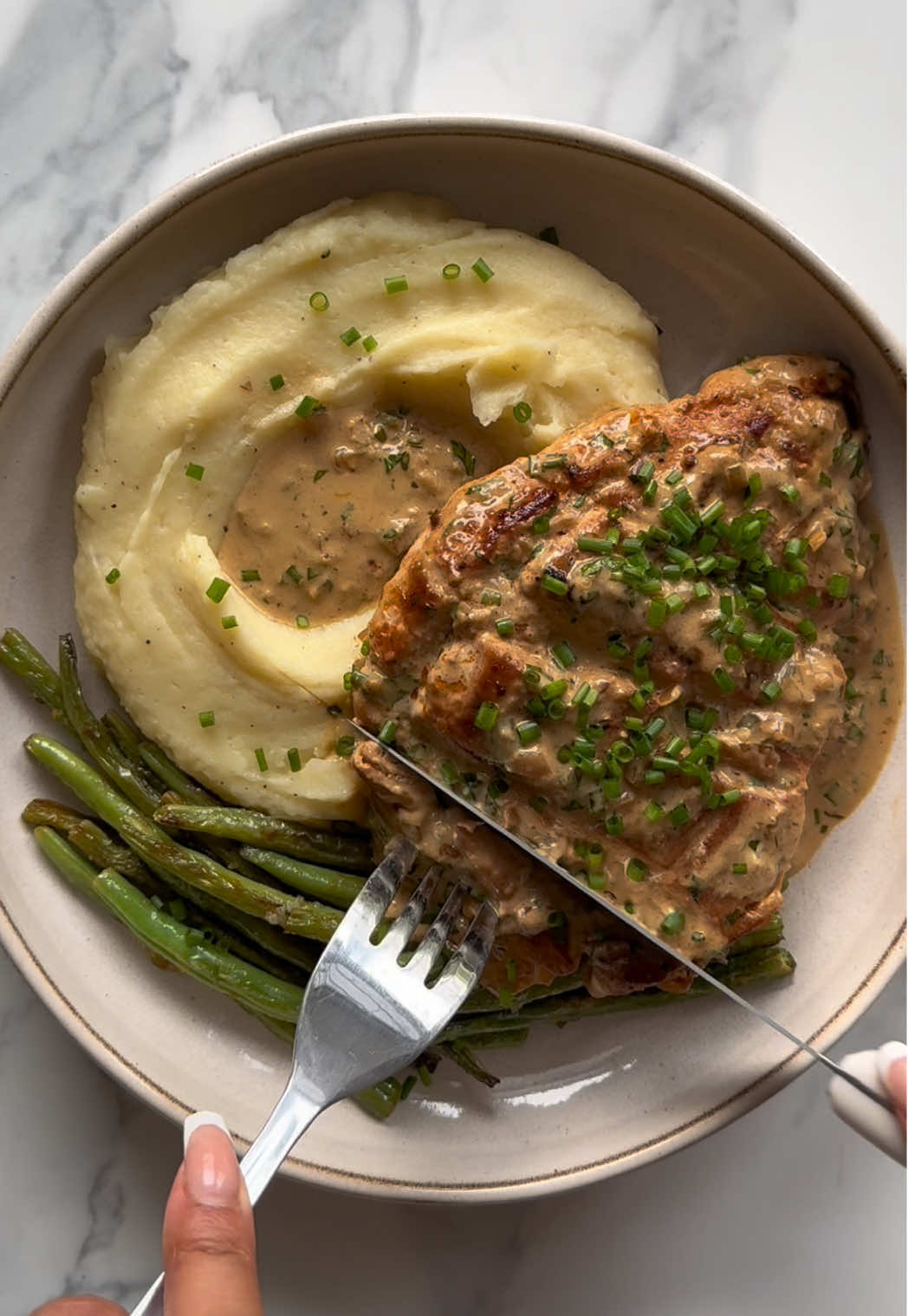 Part 5- Creamy garlic parmesan chicken with mash + greens 🥔  Protein 60g / Calorie 771  A comfort food staple !!  Recipe (Serves 1): -Rub a baking potato with olive oil and salt, prick with a fork, and cook unwrapped in the air fryer at 200°C for 50 minutes–1 hour, until the skin is crisp and a knife slides through easily. Cut it open, scoop out the flesh, (I pass through a sieve to make sure it’s extra smooth) then  mash with 1 tbsp butter, 2 tbsp milk, 1 tsp Dijon mustard, and black pepper until smooth. -Season your scored chicken breast with paprika, garlic powder, onion powder, salt, black pepper, and a drizzle of olive oil. Cook scored-side down in a hot pan for 5–6 minutes until golden, then flip and cook the other side until done. Remove and set aside. In the same pan, cook ½ a finely diced shallot for 2–3 minutes until soft, then add a minced garlic clove and cook for 1 minute until fragrant.  -Pour in 100ml chicken bone broth, let it reduce slightly, then stir in 50ml crème fraîche, 20g grated Parmesan, 1 tsp honey, parsley, chives, a squeeze of lemon juice, and black pepper. Let it bubble gently until thickened, then return the chicken and spoon the sauce over to coat. -For the beans, heat a pan with a little olive oil, add trimmed green beans, and cook until softened and starting to char. Stir in 1 minced garlic clove, the zest of ½ lemon, juice of ½ lemon, salt, and pepper, tossing until fragrant. -Serve the chicken sliced over the mustard mash with the garlic and herb cream sauce poured on top, and the lemon garlic beans on the side. #garlicchicken #mash #comfortfood #EasyRecipe #healthyrecipe  