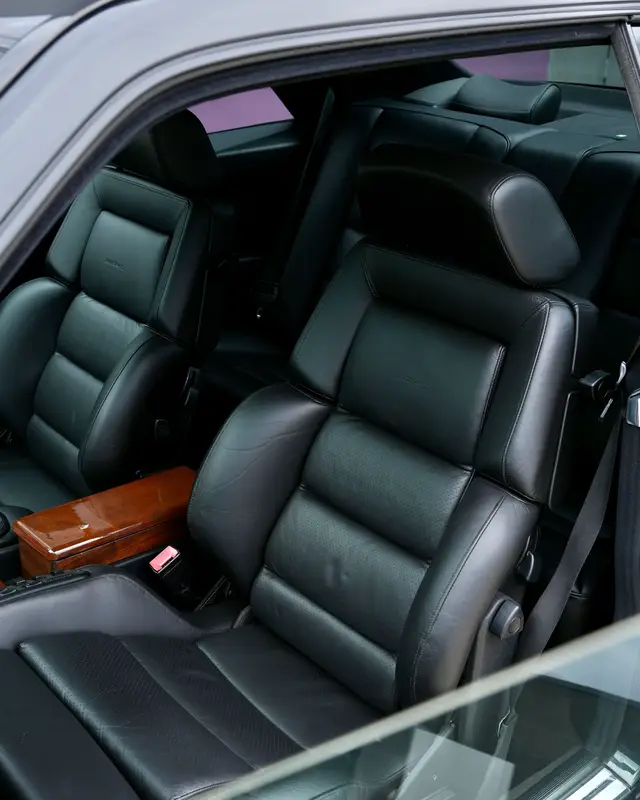 Inside the 1991 Mercedes-Benz 300 CE 3.4 AMG C124 Coupe - where craftsmanship meets power. Step inside and you’ll immediately feel what makes this AMG so special. The black Recaro leather seats embrace you with the perfect balance of sport and comfort - unmistakably 90s, yet timelessly elegant. Polished wood trim stretches across the cabin, crowned by the AMG Limited Edition badge - a subtle reminder of how rare this machine truly is. Every detail feels deliberate: the AMG-embossed Momo steering wheel, the signature automatic gear selector finished in matching wood, white AMG speedometer and the period-correct Mercedes cassette deck completing the analog perfection. Only about 50 of these coupes ever left Affalterbach, and each interior was tailored with precision and pride. #puffingarage #c124 #mercedesgts #300ce #vintagecar