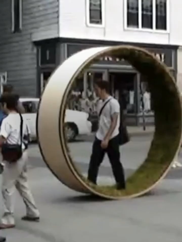 A school project that took “touch grass” literally. The “Parkwheel” (2006) by David Gallaugher, Kevin James, and Jacob Jebailey of the Dalhousie School of Architecture is a conceptual installation resembling a hamster wheel covered with grass. This cylindrical structure rotates as the person inside walks, allowing urban dwellers to experience the sensation of grass underfoot while moving through the city. #art #artist