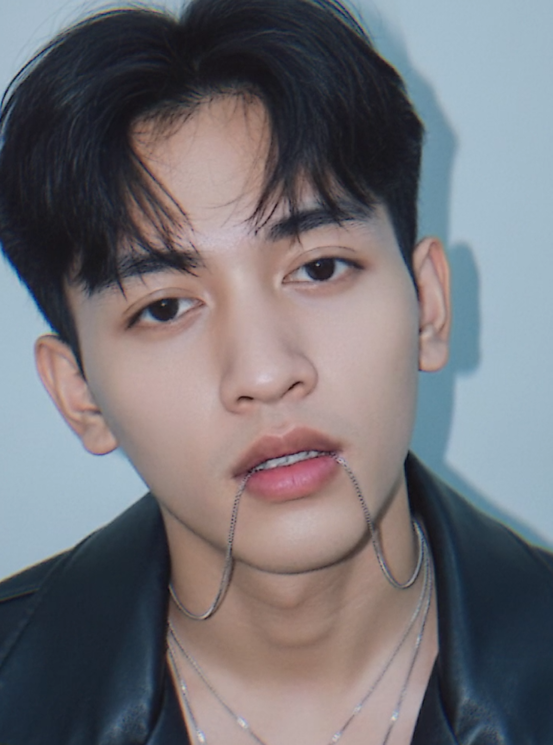 GEMINI AI Prompt : Potret close-up seorang pria muda dengan ekspresi tenang, wajah sedikit dimiringkan ke kanan dan kepala condong ke depan. Gaya visual sangat realistis dengan pencahayaan lembut dan tone dingin modern. Rambut: hitam pekat, bergaya berponi acak-acakan alami, bagian tengah membentuk sedikit belahan koma (comma hair), helai rambut di dahi jatuh natural, berkilau lembut oleh cahaya. Wajah: kulit cerah mulus dengan tekstur lembut dan realistis. Bentuk wajah tegas tapi halus, tatapan mata tenang, bibir sedikit terbuka — dari bibir bawah menjuntai rantai kalung tipis berwarna perak yang menambah kesan dramatis. Pakaian: mengenakan jaket kulit hitam terbuka bagian dada, tanpa kaos di dalam, menampilkan sebagian dada dan tulang leher. Tekstur jaket terlihat realistis, mengilap lembut, dengan jahitan detail di bagian kerah. Aksesori: Tiga kalung perak tipis melingkar di leher, masing-masing dengan liontin logam berbentuk bulat kecil dan simbol X di tengahnya.Salah satu rantai kalung tersangkut di bibir bawahnya secara natural. Permukaan liontin mengkilap dengan pantulan cahaya lembut. Pencahayaan & suasana: Cahaya lembut biru-putih dari sisi kanan wajah, menghasilkan bayangan lembut di sisi kiri. Latar belakang polos dengan gradasi warna biru muda ke abu muda, memberi kesan minimalis dan fokus pada subjek. Ada sedikit efek glow halus di sekitar rambut dan kulit, menambah nuansa dreamy namun tetap realistis. Gaya visual: Fotorealistik ultra detail, dengan pencahayaan sinematik lembut, tone warna dingin, depth of field sangat dangkal (fokus hanya di wajah dan kalung). Warna natural tapi sedikit disaturasi, menyerupai hasil kamera profesional atau artwork 3D ultra-realistis. #creatorsearchinsights #fyp #xybca #foryou #trendingtiktok 