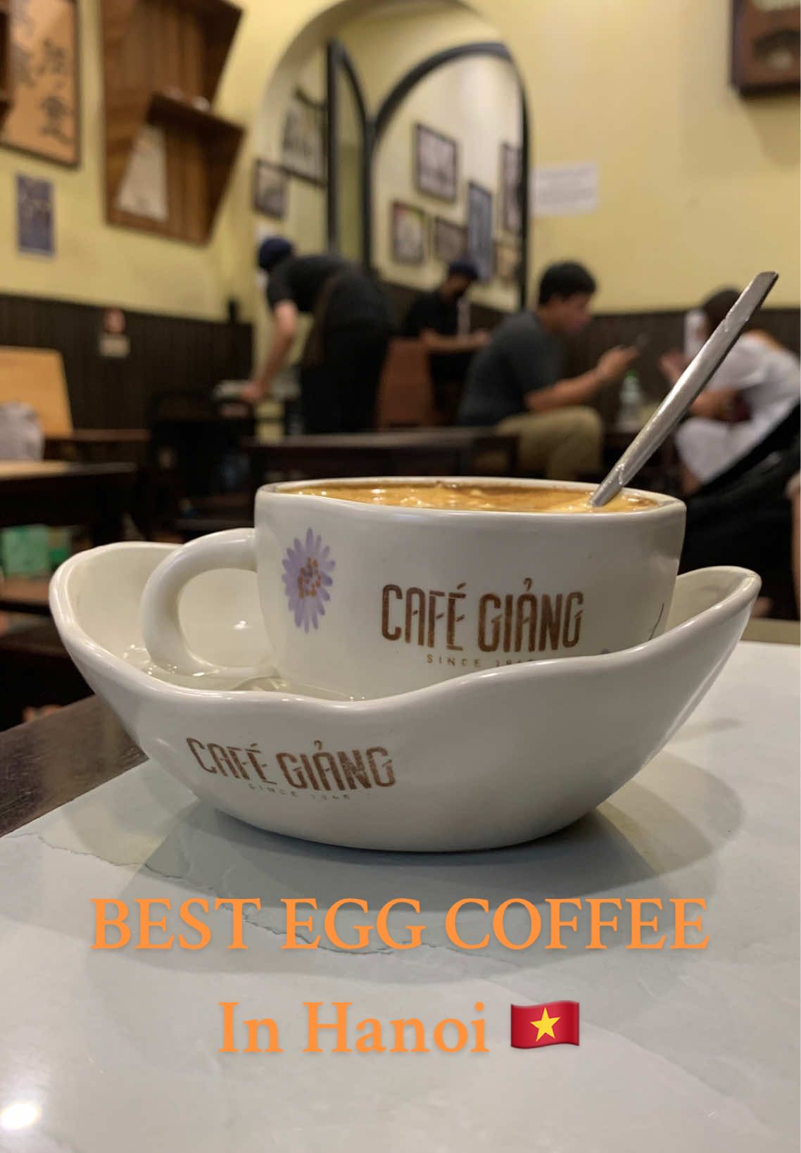 Le meilleur Egg Coffee d’Hanoï – Café Giang, depuis 1946 Niché dans une ruelle discrète du vieux quartier de Hanoï, le Café Giang est bien plus qu’un simple café : c’est le berceau du célèbre “egg coffee” vietnamien, inventé ici en 1946 par Nguyen Van Giang, ancien barman du Sofitel Metropole. À cette époque de pénurie de lait, il eut l’idée audacieuse de battre du jaune d’œuf avec du sucre et du café fort, créant ainsi une mousse riche et veloutée, déposée sur un expresso intense. Le résultat ? Une expérience unique, à mi-chemin entre le tiramisu et le cappuccino, où le café se fond dans une crème onctueuse et légèrement caramélisée. Aujourd’hui encore, les visiteurs du monde entier viennent savourer cette recette transmise de génération en génération, servie dans de petites tasses gardées au chaud dans un bol d’eau chaude — comme un hommage au passé et au savoir-faire vietnamien. #eggcoffee #eggcoffeehanoi #hanoicoffee #hanoi #cafehanoi 