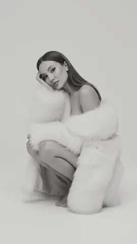 Prompt: Al never looked this expensive. Using my picture create an image A black and white studio photograph of a woman sitting in a squatting pose, wrapped in a large fluffy white fur coat. Her bare shoulders and legs are partially visible, while she leans her head gently against her hand. The background is plain and minimalistic, creating a soft fashion editorial look. The image has a refined, elegant atmosphere, resembling a professional magazine photoshoot. Don't not change facial features or body #aiprompt #ai #gemini #geminiprompt #photography