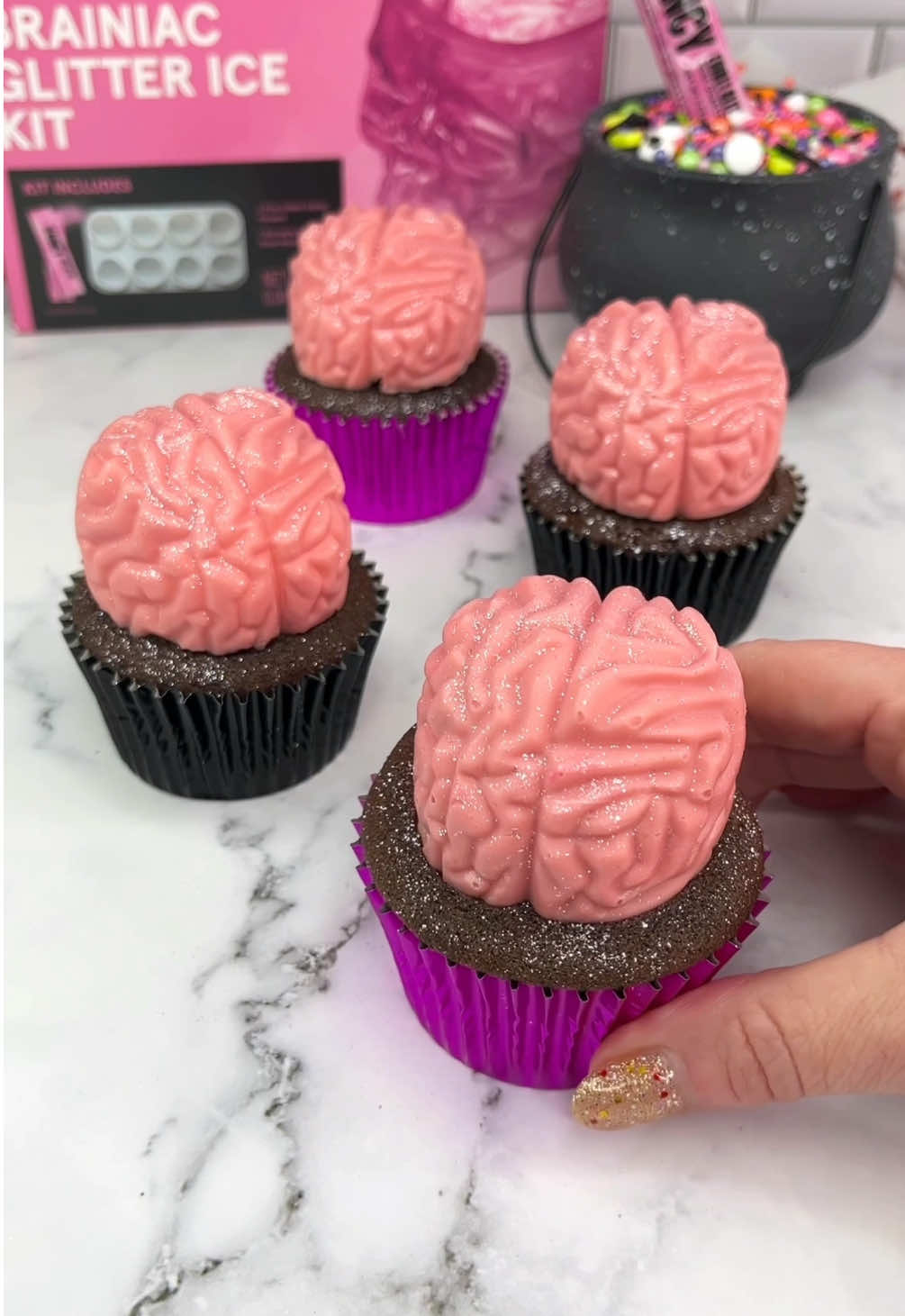 Sparkly brain cupcakes ✨🧠🧁 Give your cupcakes brains 🧠 I used @fancysprinkles Braniac Glitter Kit for the mold and the glitter 💖 🧠 Add pink candy melts to the mold and coat the sides with a spoon. Let it set. 🧠 Fill the centres with pink buttercream. 🧠 Add strawberry sauce to the middle of the buttercream.  🧠 Sit your baked cupcakes on top. 🧠 Freeze them for 15 minutes.   🧠 Push them out of the mold. 🧠 Impressive 🥳 ✨ Use a small brush and dust with glitter. #cupcake #cakedecorating #halloweenideas #HalloweenTreats #cakedbyrach     