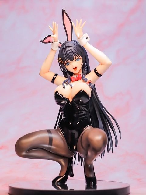 Anime-style figurine of a woman in a black bunny costume, with long dark hair, bunny ears, and a red bow tie, posing playfully on a circular base against a pink gradient background.