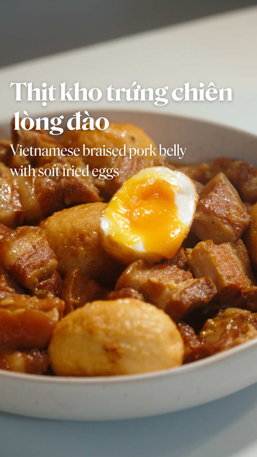 Thịt kho trứng chiên lòng đào - trứng mềm péo tan trong miệng quá là ngon.  Công thức: 800g thịt ba chỉ 3 muỗng nước mắm Xíu xiu nước màu/ nước hàng Hành tím Tỏi Tiêu Ớt nếu thích ăn cay 1-2 trái dừa Trứng gà 1. Ba chỉ cắt cục to, ướp nước mắm, hành tỏi, xíu xiu nước màu không cần cũng được 2. Hầm với nước dừa, lửa thật nhỏ, hầm 4-5 tiếng (thời gian hầm tuỳ theo sở thích) 3. Trứng gà ở nhiệt độ phòng, luộc đúng 5p15s tính từ lúc nước sôi, thả chậm chậm nhẹ nhàng, nước sôi vừa phải để tránh trứng bị vỡ trong lúc luộc. 4. Nếu trứng gà lạnh, có thể tăng thời gian luộc lên 15s-30s 5. Vớt trứng ra thau đá để dễ lột hơn, lau khô trứng sau khi lột để chiên không bị bắn dầu 6. Dùng chảo nhỏ (để đỡ hao dầu), để lửa lớn vừa chiên 2 mặt trứng thật nhanh rồi vớt ra 7. Khi thịt đã mềm, nếm lại theo khẩu vị nêm đường, mắm, v.v tuỳ thích 8. Tắt bếp, cho trứng vào rồi đậy nắp 9. Hạn chế hầm trứng thêm quá lâu để tránh trứng không còn lòng đào 10. Nếu ăn vào ngày hôm sau, để trứng riêng, khi hâm lại thịt hẳn bỏ trứng vào để trứng vẫn còn lòng đào. #anuong #nauan #nauancungtiktok #comnha #thitkho 