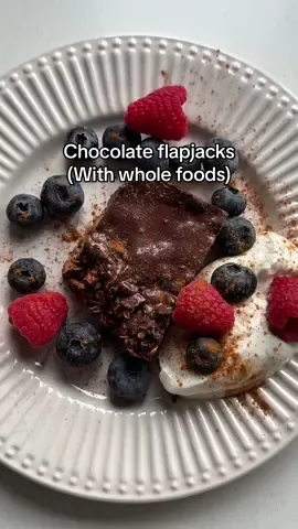 Chocolate *whole foods* flapjack: INGREDIENTS:  - Rolled oats 150g - Medjool dates (pitted) 7 dates  - Nut butter (e.g. almond, peanut, or cashew) 80g - Coconut oil (or unsalted butter) 45 g                - Maple syrup or honey 30 g                - Vanilla extract 5g (1 tsp) - Sea salt 1–2 g (1/4 tsp) - Sweet ground cinnamon (optional) 1–2 g - Dark chocolate chips (70%+) 75 g - Chia seeds 20g           Optional topping: - 90g dark chocolate  - 2 tbsp coconut oil  RECIPE:  1. Preheat oven to 165°C. Line an 20x20 cm (8x8 inch) baking tin with parchment paper. 2. In a saucepan, gently melt together the coconut oil, almond butter, and maple syrup. Stir until smooth and well combined. 3. In a large bowl, combine the oats, salt, nuts, and dried fruit. 4. Pour the wet ingredients into the dry ingredients. Mix well until all the oats are coated.  5. Add the vanilla extract.  6. Press the mixture into the lined tin. Use the back of a spatula or your clean hands to pack it down firmly. 7. Bake for 15-20 minutes, until golden at the edges 8. OPTIONAL: Heat the dark chocolate and coconut oil in a bowl over a boiling saucepan for 6-8 minutes until completely melted. 9. Cool completely in the tin before pouring over the topping mixture. Allow the chocolate topping to completely cool before cutting into squares. 10. If not including the topping, still allow the flapjacks to completely cool down before cutting.  #flapjacks #sweettreat #breakfast #wholefoods 