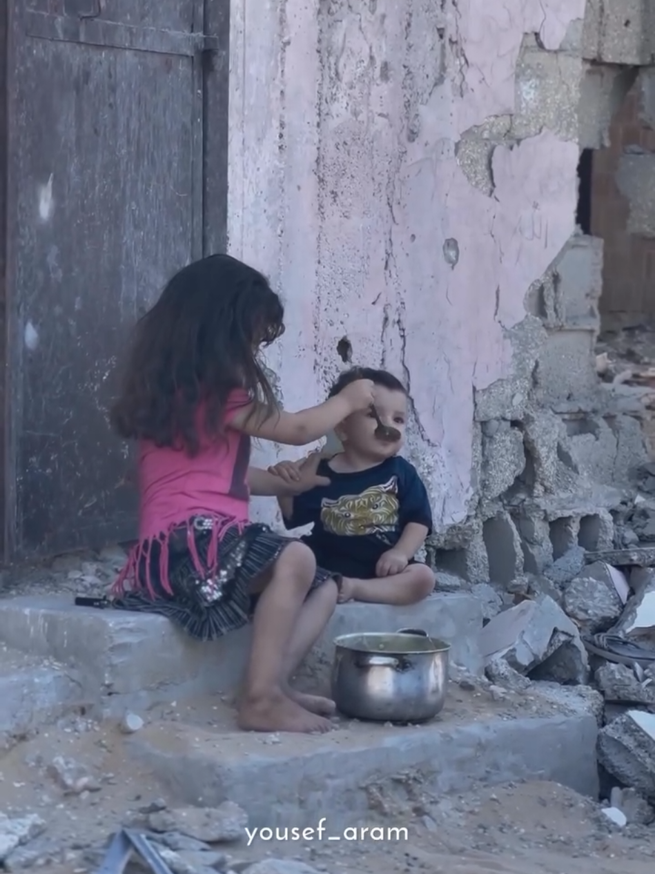 A little girl feeds her little brother amidst the ongoing famine in Gaza.