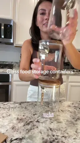 Glass food storage jars with the cutest wood lids & attached scoopers. These are perfect if you’re trying to ditch the plastic like us!  #glassfoodcontainer #glassjars #foodstoragecontainers #dryfoodstorage 