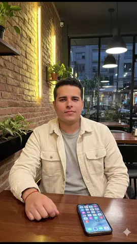 Segue para mais.✌🏽😎 Use o PROMPT e compartilhe nos comentários. PROMPT:(Use a foto em anexo como modelo do rosto do Homem.  Crie uma imagem hiper-realista de um homem sentado em uma mesa de madeira em um ambiente acolhedor e elegante, como um restaurante ou café com iluminação quente e moderna. Ele veste uma sobrecamisa ou jaqueta de veludo cotelê em tom claro, sobre uma camiseta casual. A mão apoiada na mesa exibe uma  uma pulseira vermelha fina no pulso. Um Iphone está sobre a mesa, com a tela acesa voltada para cima, mostrando diversos ícones de aplicativos. O ambiente ao fundo apresenta paredes de tijolos aparentes, iluminação amarelada embutida em nichos ovais verticais e elementos decorativos como plantas e janelas de vidro. Também há detalhes modernos, como luminárias pretas e reflexos de luz nas superfícies. A cena transmite um clima noturno, aconchegante e urbano, com sensação de relaxamento e estilo contemporâneo. Estilo realístico e detalhado. Size 1024x1024) #gemini #trend #fyp #viral #USA 