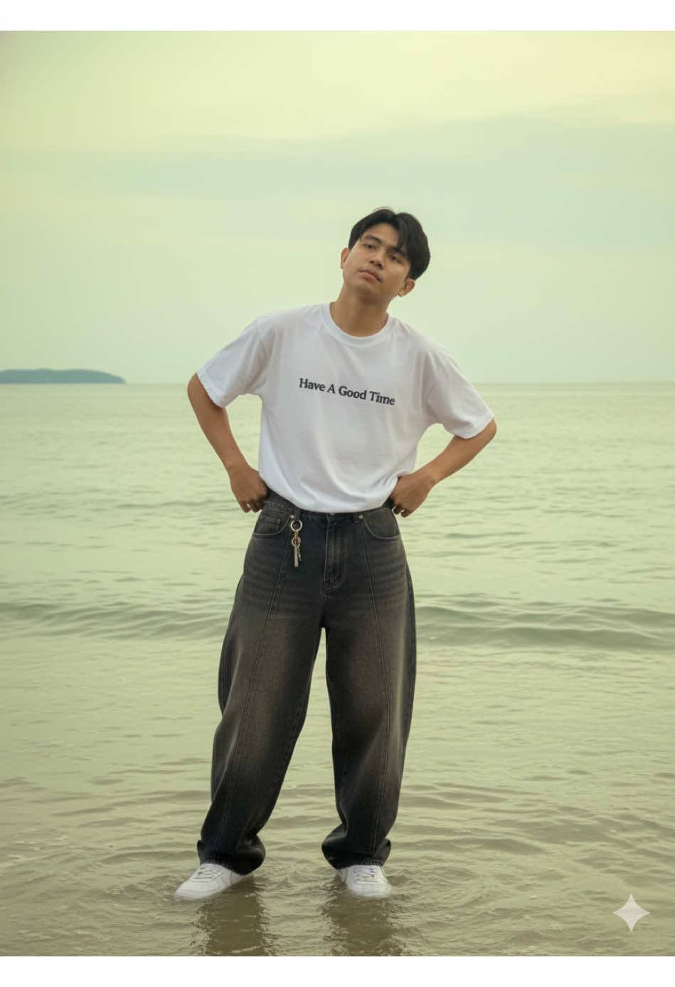 Prompt Gemini AI: Foto menggunakan wajah asli saya, buatkan gambar potret dengan konsep sebagai berikut! Seorang pria muda berdiri di tepi laut yang dangkal, tepat di atas permukaan air yang tenang dan sedikit beriak. Ia mengenakan kaos oversized putih bertuliskan 