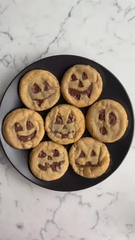 Halloween Pumpkin Cookies  Ingredients * 50g White sugar * 200g Light Brown sugar * 170g Unsalted butter, browned and slightly cooled * 1 Large egg, room temp * 2 tsp Vanilla extract * 250g All-purpose flour * 1 tsp Baking powder * ½ tsp Baking soda * ¾ tsp Salt * 200g Chocolate chunks for filling and carving features Brown the butter: Melt butter over medium heat until golden and fragrant. Let it cool slightly. In a mixing bowl, combine white sugar, brown sugar, and browned butter. Add egg and vanilla extract, mix until fully incorporated. In a separate bowl, whisk together flour, baking powder, baking soda, and salt. Gradually add dry ingredients into the wet mixture. Stir until a dough forms – avoid overmixing. Scoop dough into balls 60g each. Flatten slightly, place a chocolate square or chunk in the center, and cover it with more dough. Smooth edges. Gently press the cookie tops. Use a small knife or cookie cutter to carve jack-o’-lantern faces. Place on a lined tray and freeze for 1 hour. Preheat oven to 180°C. Bake for 10–12 minutes or until edges are lightly golden and centers look just set. Cool on baking tray for 5 mins, then transfer to a wire rack for 10 mins, and Monappetito!! #halloween #cookie #chocolate #monappetito #jackolantern 