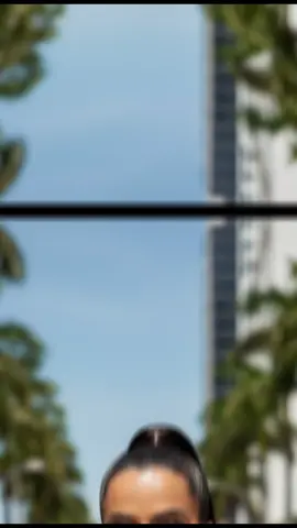 1.Utilizando a foto enviada para fazer o rosto.Faça uma fotografia de moda urbana em um dia ensolarado, cenário ao ar livre com palmeiras alinhadas e prédios modernos ao fundo. Mulher jovem e elegante, pele bronzeada, corpo esguio, usando um conjunto sofisticado em tom cinza claro: top cropped ombro a ombro, estruturado e levemente franzido, combinado com calça de alfaiataria de cintura alta, pregas sutis e cinto da mesma cor.Ela usa óculos de sol grandes e arredondados com armação clara, brincos de argola dourados e um colar delicado com pingente redondo dourado. O cabelo está preso em um rabo de cavalo alto e liso, caindo pelas costas. Postura confiante, mãos nos bolsos, expressão séria e sofisticada. Estilo editorial de moda, fotografia em alta definição, iluminação natural forte com contraste equilibrado, cores quentes e vibrantes, foco nítido na modelo com fundo levemente desfocado (bokeh). #prompts #gemini #ConteúdoDeAltoImpacto #trends 