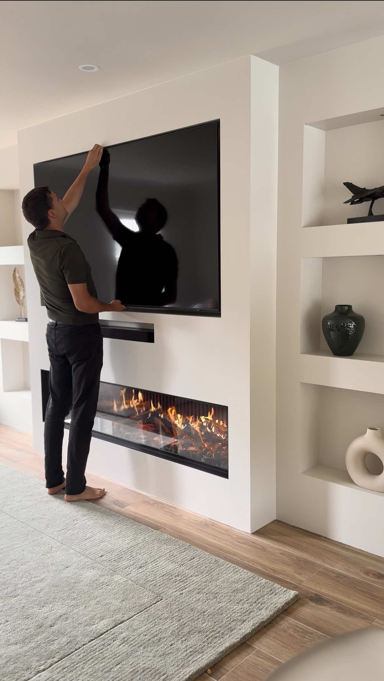 We’ve had so many lovely messages about our media wall, especially asking: “Where do you plug everything in?” Behind the TV, we built a recessed shelf that hides all the tech — no wires in sight! We added 8 sockets, 4 CatD ports, and a TV aerial, powering the TV, soundbar, fireplace, and shelf lighting with room to spare. #homehacks #hack #tip #homedecor #renovation 