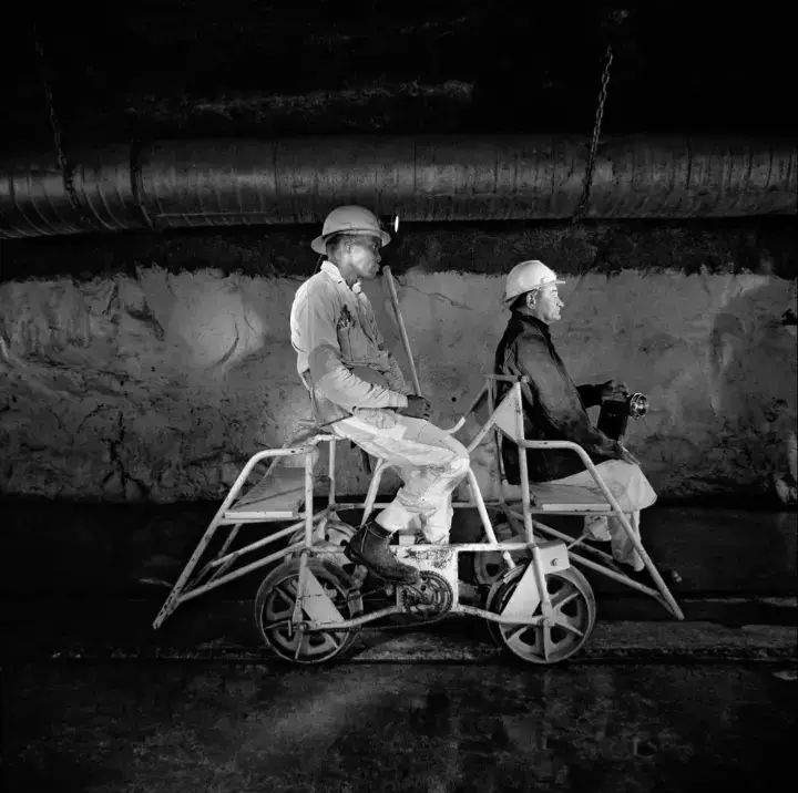Team leader (left) and mine captain (right) on a pedal car, Rustenburg Platinum Mine, Rustenburg, 1971. [Photograph by David Goldblatt/Goodman Gallery]