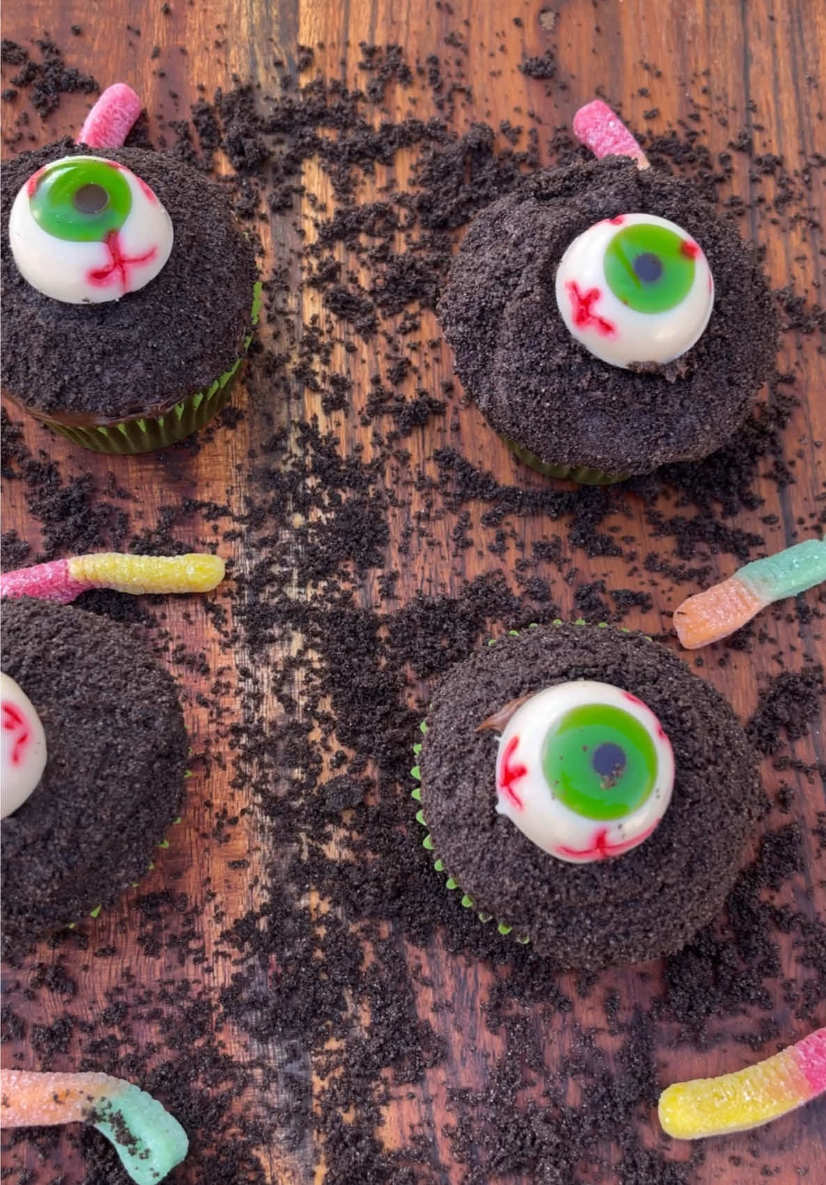 EYEBALL GRAVEYARD CUPCAKES‼️🔥🧁😱 Perfect for spooky scary season 👻🙌🏽 #halloween #eyeball #fyp #reels #Foodie   ➡️ Check out my Amazon storefront (link in bio) to find everything you need to create these! ⁣ 💥INGREDIENTS💥  - Chocolate Cupcakes (boxed or store purchased) - Chocolate Frosting (homemade or store purchased) - Oreos - Gummy Worms - Edible candy eyeballs ✨INSTRUCTIONS✨ - Cook your chocolate cupcakes and allow them to cool completely. - Make your chocolate frosting and set aside. - Pulse your Oreos into a fine crumb and put them in a medium sized bowl. - Frost your cupcakes. - Dip your frosted cupcakes into the oreo crumbs to completely the cupcake with your “dirt”. - Lay your gummy worms and your eyeballs on top of your dirt. And ENJOY! 🤤