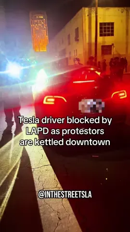 LAPD blocked off streets as protestors were being kettled into an alley near the Detention Center. A man in a Tesla tried to get through.. Stopped at the blockade, he had one thing to say.