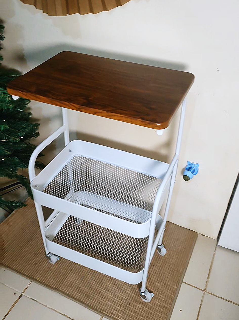 This is a 2-tier rolling storage cart with a wooden tabletop a perfect blend of style and functionality The top layer features a smooth wooden surface ideal for placing drinks, décor, or small appliances, while the bottom section includes a sturdy white metal mesh basket for organizing essentials like books, kitchen items, or bathroom supplies Its compact design and easy-rolling wheels make it perfect for small spaces whether in the living room, kitchen, office, or bedroom Simple, modern, and versatile — a must-have for anyone who loves organized and minimalist interiors #bedsidetable  #coffeetable  #storagesolutions  #minimalistdesign  #SpaceSaver 