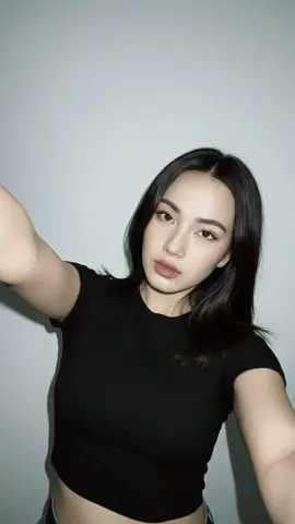 Another realistic AI pic 💕 Gemini AI Prompt:  Create realistic portraits (100% reference to the face, ears, nose, mouth and face shape from the person in the virtual image, do not edit) She’s 28 years old and eyes are dark brown Portrait of a young woman, do not change the original face. Taking a selfie with the 0.5x rear camera, angle taken from above near the face. She reached out to hold the camera with one hand. Chic and sexy, wearing a black vintage crop top. The background is a smooth white wall. There are a few decorations on the right. Using a strong flash like a 2000s digital camera, the light is blurry, slightly overexposed, and the tone is grainy and the feeling of Nostalgia. There’s no phone visible in the picture #GeminiAI #geminiprompt #geminitrend #fyp 