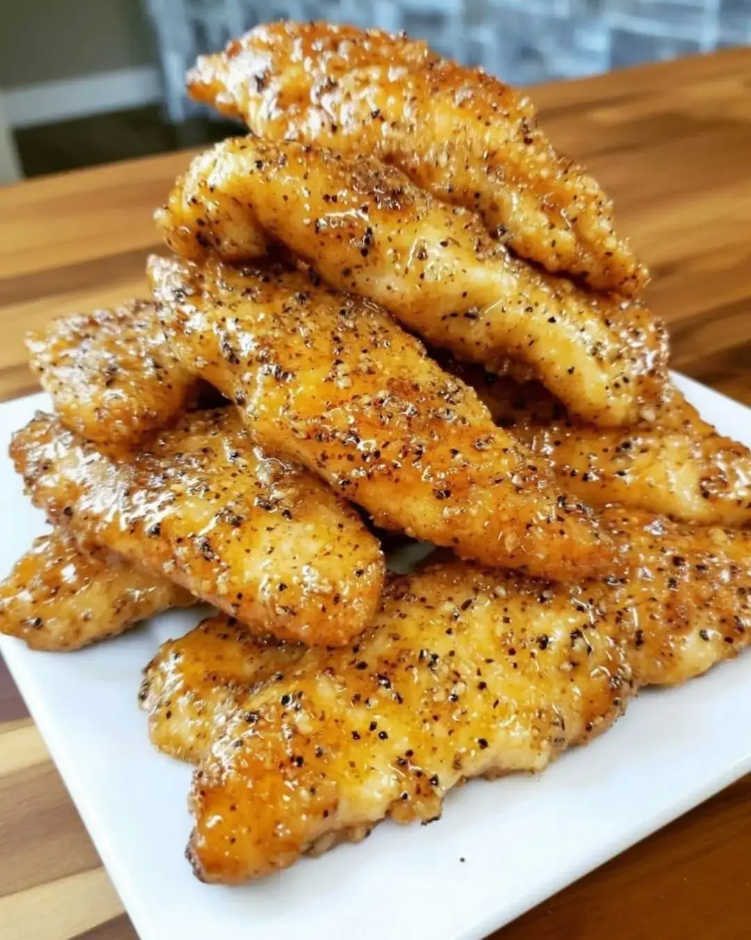 🍯🧄🍗 AIR FRYER HONEY BUTTER GARLIC CHICKEN TENDERS 🍗🧄🍯 Crispy, juicy chicken tenders coated in a sweet and savory honey butter garlic sauce, perfect for a quick weeknight dinner or a delicious snack! 📋 Ingredients: 1 lb chicken tenders   ¼ cup honey   2 tbsp unsalted butter, melted   3 cloves garlic, minced   1 tsp paprika   1 tsp salt   ½ tsp black pepper   1 cup breadcrumbs (panko or regular)   Cooking spray   🔪 Directions: 1. **Prepare the Honey Butter Mixture:** In a small bowl, combine melted butter, honey, minced garlic, paprika, salt, and black pepper. Mix well until combined. 2. **Coat the Chicken Tenders:** In a separate bowl, add the breadcrumbs. Dip each chicken tender into the honey butter mixture, allowing excess to drip off, then coat evenly with breadcrumbs. 3. **Preheat the Air Fryer:** Preheat your air fryer to 400°F (200°C) for about 5 minutes. 4. **Arrange the Chicken Tenders:** Lightly spray the air fryer basket with cooking spray. Place the coated chicken tenders in a single layer in the basket, making sure they are not overcrowded. 5. **Air Fry the Chicken Tenders:** Cook the chicken tenders in the air fryer for 10-12 minutes, flipping halfway through, until they are golden brown and cooked through (internal temperature should reach 165°F or 75°C). 6. **Serve and Enjoy:** Remove the chicken tenders from the air fryer and drizzle with any remaining honey butter mixture if desired. Serve warm with your favorite dipping sauce! 🕒 Nutritional Information:   ⏰ Prep Time: 10 minutes | Cooking Time: 12 minutes | Total Time: 22 minutes   🔥 Kcal: Approximately 300 kcal per serving | 🍽️ Servings: 4 servings   #AirFryerChickenTenders #HoneyButterGarlic #QuickDinner #CrispyChicken #EasyRecipes