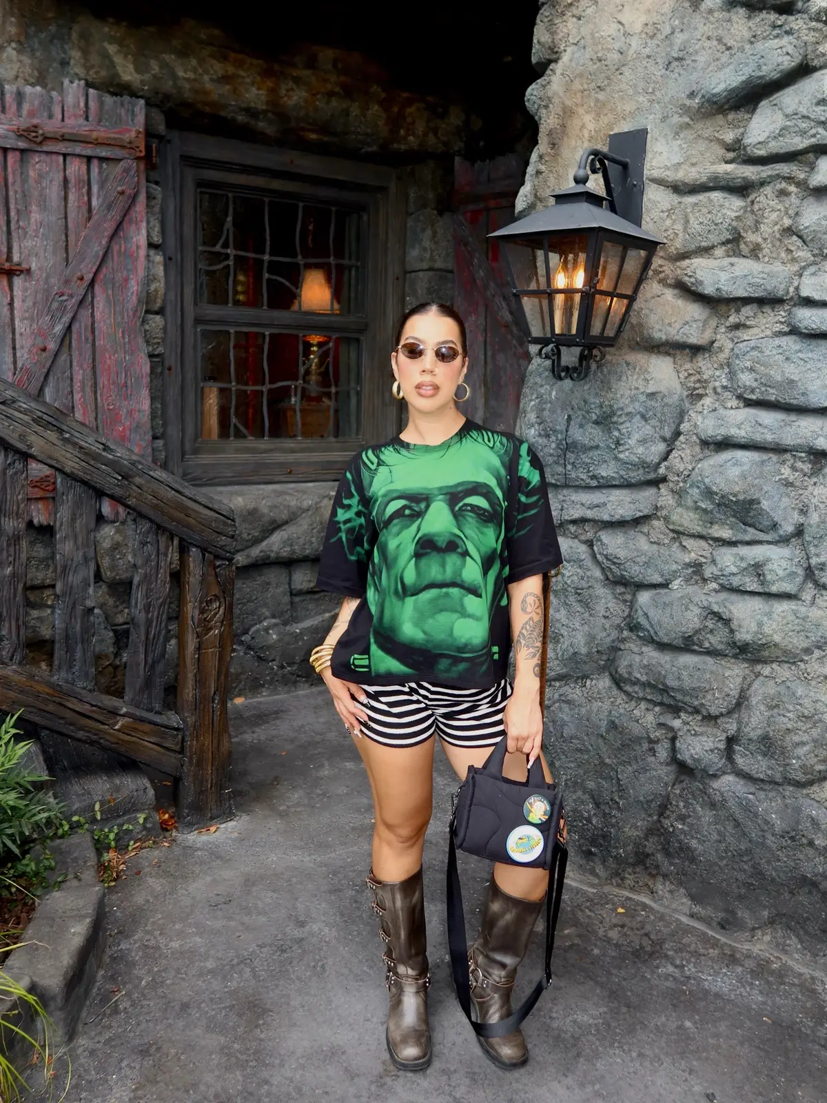 Some Epic Universe outfit Inspo and details 👻: Shirt - vintage @ebay  Shorts - @ThredUp Inc  Boots - @stevemadden  Bag - @Thirty Years  #epicuniverse #epicuniverseorlando #darkuniverse #frankeinstein #halloweenootd 
