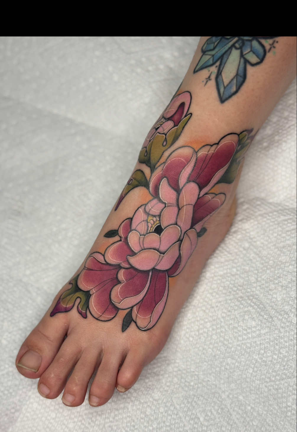 Koda let me do whatever I wanted on her foot with the restriction of full color floral 🌸  How do you think it turned out? Would you give your tattoo artist free reign? 🤗  #iowatattooartist #foottattoo #girlswhotattoo 