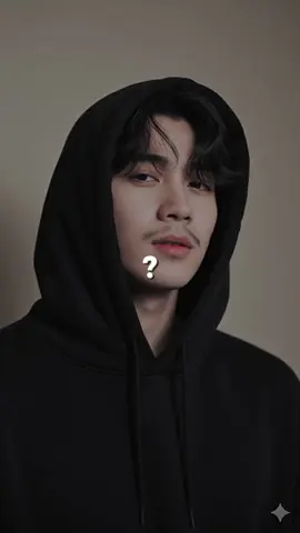 prompt 👇  Ultra-realistic close-up portrait of a handsome young man (foto attached) with fair smooth skin, wearing a black hooded sweatshirt with the hood fully up. The photo is taken from a slightly low angle, just below the chin level, looking up toward his face, emphasizing his jawline and lips.His head is slightly tilted backward, and he's looking downward toward the camera with a subtle, confident, and alluring expression. His lips are gently closed, slightly pouty, with a soft pink color. His black hair is messy and falls naturally over his forehead, partially covering one eye and blending into the shadow of the hood.The hood fits snugly around his head, made of thick, matte black fabric with visible seams and two black drawstrings hanging loosely. The lighting is soft and diffused indoor light, coming from the front-left side, creating a gentle highlight on his nose and lips, and a mild shadow under the chin.Background is minimal a plain beige wall with smooth gradient lighting, no objects or textures. The overall mood is moody and intimate, with a cool, realistic photographic tone, shallow depth of field, and high detail in skin texture, lips, and hair strands. No stylization, no filters - purely realistic photography, like a natural unedited portrait shot with a DSLR camera. #fyp #masukberanda #fy #gemini #trend 