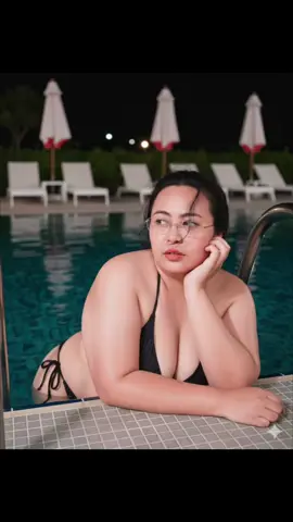 ทูพีช👙#แจกฟรี #GeminiAi #prompt  สร้างภาพพอร์ตเทรตสมจริงของหญิงสาว (คงใบหน้าและลักษณะเหมือนต้นฉบับ 100% ห้ามแก้ไข) หญิงสาวตัวอยู่ในน้ำข้างบันไดเหล็กริมสระว่ายน้ำกลางคืน พื้นกระเบื้องรอบสระเป็นลายสี่เหลี่ยมเล็ก ๆ สีเทา ด้านหลังมีร่มสนามพับเก็บไว้สีขาวขอบแดง และเก้าอี้นอนสีขาวเรียงกัน ไฟในสระและบริเวณรอบๆ ให้แสงอุ่นสลัวๆ หญิงสาวอยู่ในท่าแขนข้างซ้ายพาดริมสระ คางวางบนมือขวา เธอสวมชุดว่ายน้ำบิกินี่สีดำแบบผูกเชือกด้านข้าง ใส่แว่นตาไร้กรอบทรงแคบ(เหมือนกำลังตกลงมาปลายจมูก) ผมทรงเดิม มีปอยผมปิดหน้าเล็กน้อย เอาดอกไม้ที่หูออก ปลิวตามลม เก๋เท่ปนเซ็กซี่ มีวอลลุ่ม ปัดแก้มสีชมพู มีแก้มและจมูกสีระเรื่อ ริมฝีปากโทนชมพูอมส้มอวบอิ่ม ผิวขาวนวลสะท้อนแสงแฟลช หันหน้ามองด้านข้าง สีหน้าน่ารัก เพ้อฝันซื่อๆและขี้เล่น บรรยากาศโดยรวมดูเงียบ หรู และเซ็กซี่เล็กน้อย โทนและกล้อง: ภาพถ่ายด้วยกล้องดิจิทัลยุค 2000 (Canon IXUS, Sony Cyber-shot, Casio Exilim) ใช้แฟลชตรง (direct flash) ในตอนกลางคืน โทนภาพขาวอมชมพูและโทนผิวสว่าง มีเกรนเล็กน้อย รายละเอียดผิวเห็นชัด เงาสะท้อนบนผิวจากแฟลชโดดเด่น