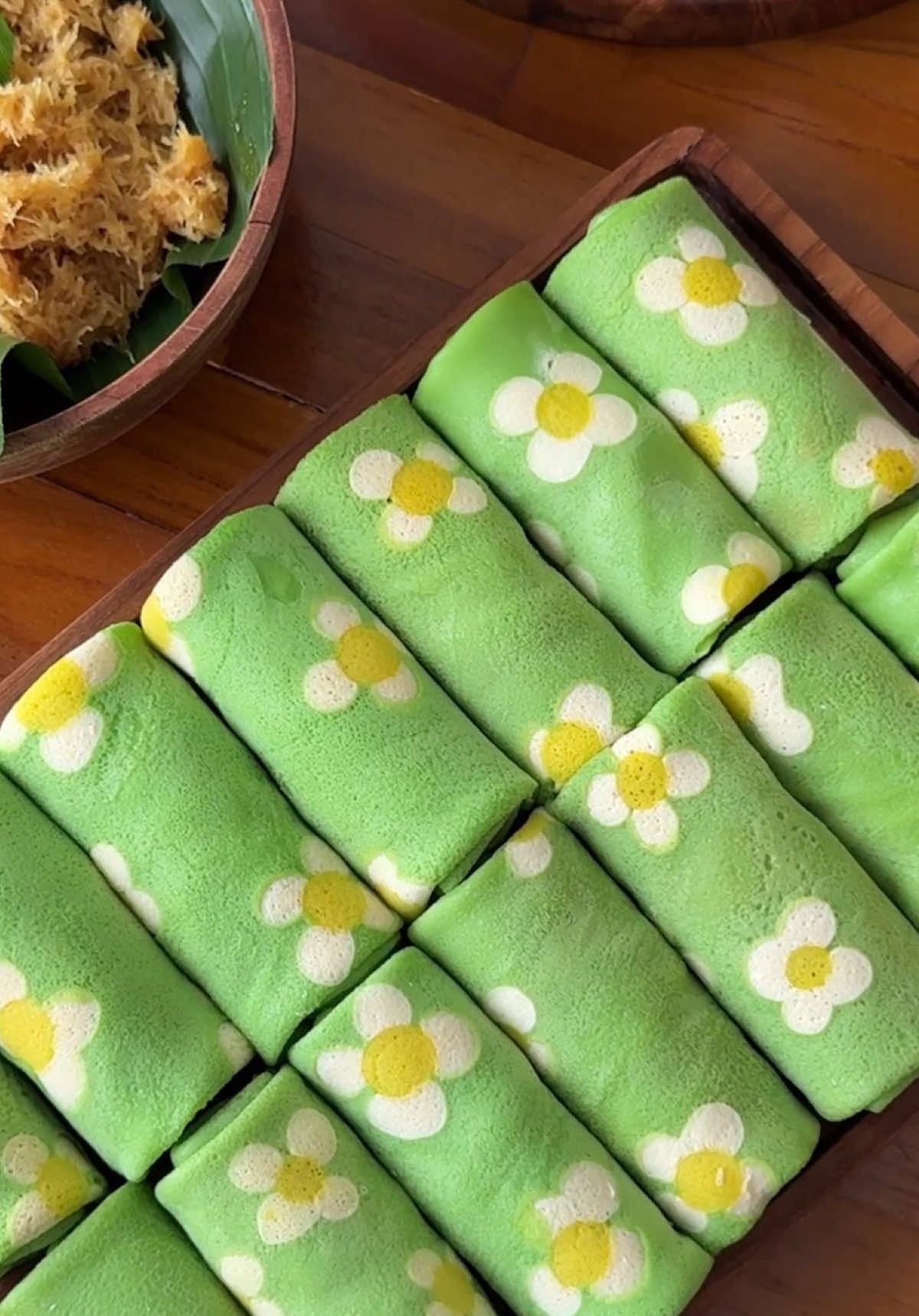 Dadar gulung next level ini mah, kesabaran terbayar karena hasilnya emang cakep banget 😭. Sempet latihan beberapa kali supaya motif bunganya gak bleber 😮‍💨, pokoknya klean ikutin aja cara tuang adonan motifnya kaya divideo 😬, klo berhasil tag aku yah 😬  Masak pake Glow Pan Wood dari @Steincookware Official Store  Resep kulit Bahan A 250 gr terigu protein sedang 2 telur 20 gr gula halus 250 ml air 1 sachet santan instan 65ml 1/4 sdt garam 1 sdm minyak Bahan B  300 ml juice pandan ( aku pakai daun suji dan pandan ) Pewarna kuning , putih(optional) , pewarna hijau muda Cara : • Campur semua bahan A, aduk rata, ambil sedikit adonan inj untuk motif  Masukan juice pandan disisa adonan, aduk rata kembali & saring  • tambahkan pewarna kuning & pewarna putih untuk adonan motif  • dadar adonan kulit ** lihat video •Resep Unti Kelapa 220 gr gula merah / aren + 200ml air, masak hingga gula mencair + saring - 1 butir kelapa setengah tua ( -/+ 400-450gram ) Parut memanjang 3 lembar daun pandan 1/4 sdt garam Cara : Masak semua bahan diatas sampai gula meresap ( tidak terlalu kering / basah ) #MasakTanpaMinyak #GlowPan #PanciAntiLengket #SteinCookware