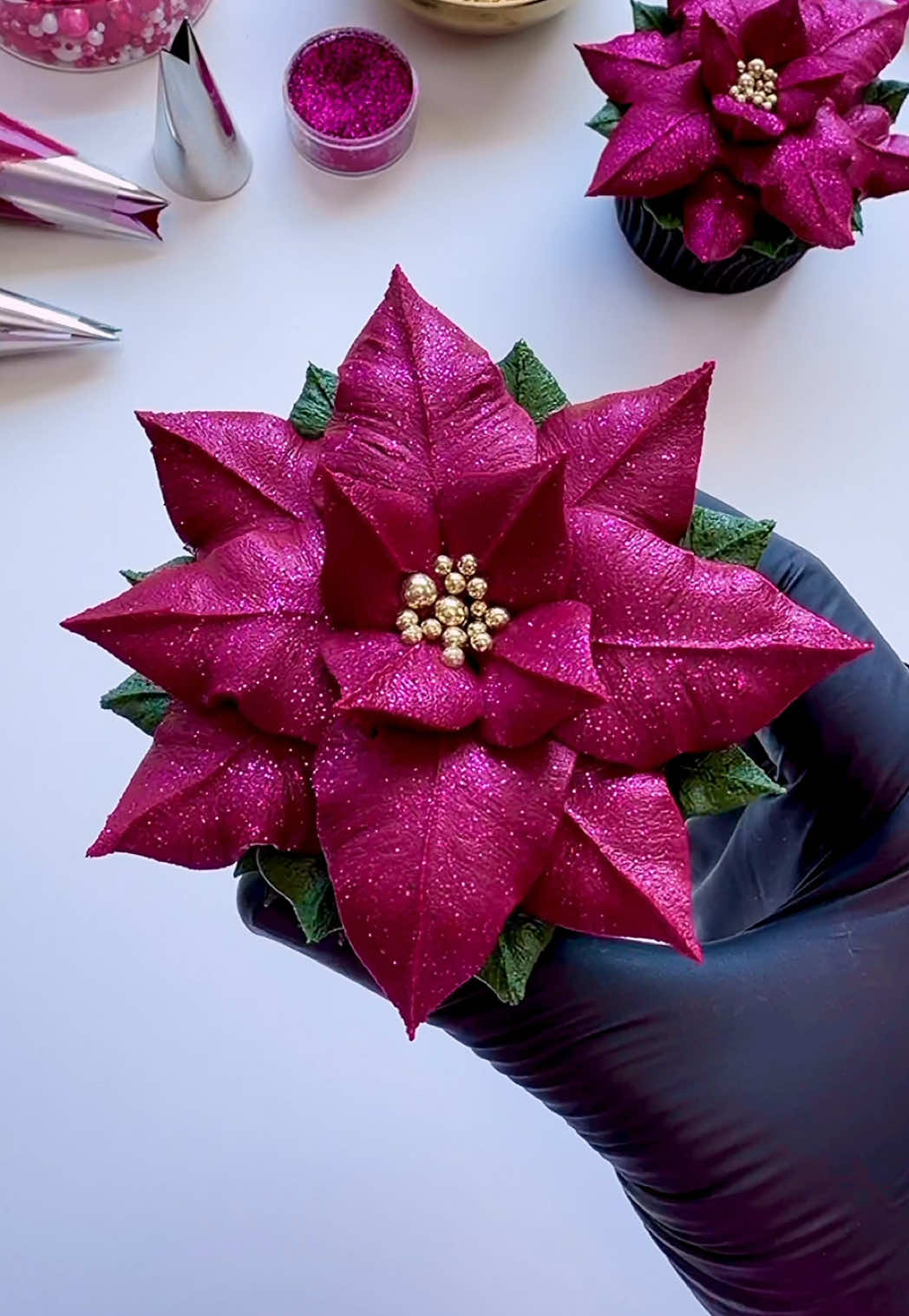 A sparkly, burgundy buttercream poinsettia ❤️💕 Yes, it is a bit early for Christmas but our social feeds are already full of festive content and we can’t help feeling a little excited!! ☺️ #cupcakedecorating #poinsettia #cupcakeart #christmas #christmasiscoming 