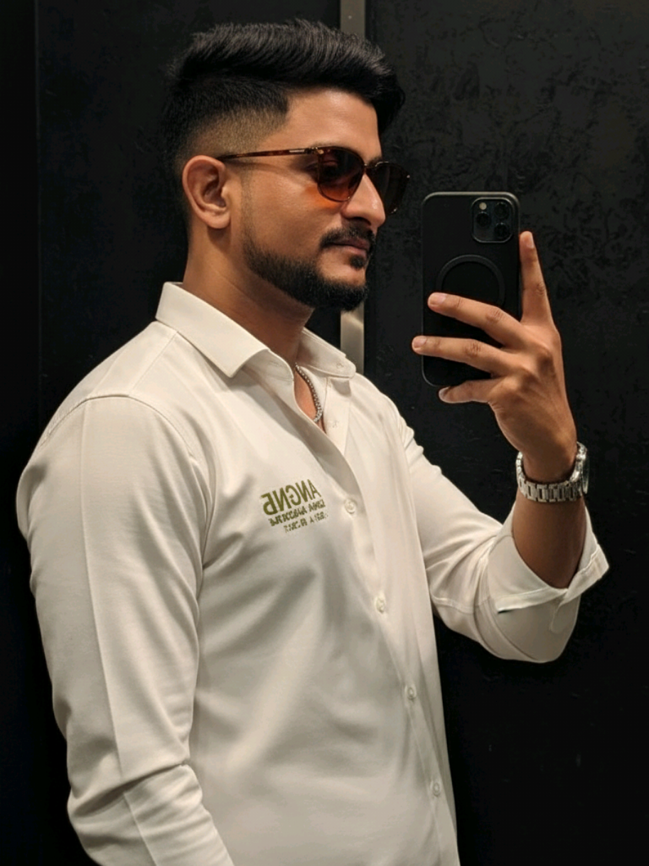 Ultra-realistic close-up mirror selfie portrait of a young man standing in a dark modern room with a black textured wall background. The camera captures him from the side profile, very close — just like a cinematic frame — his face, shoulder, and phone filling the shot. He holds a black smartphone near his cheek, fingers resting naturally on the phone edge, as he looks at his reflection with a soft, confident expression. His short black hair is style —, giving sharp volume and clean edges under the soft light. He’s wearing a black reshmi shirt (not T-shirt), with smooth shiny fabric reflecting subtle highlights, giving a rich elegant vibe. He also wears brown sunglasses, a silver chain, a silver watch, completing his classy modern style. The lighting is soft and moody, with a warm glow sliding across his cheekbone, nose, and lips — creating deep cinematic shadows and golden reflections. Every detail — hair texture, fabric folds, skin tone, jewelry shine, and phone reflection — appears 8K ultra-detailed, cinematic, and realistic. The pose, camera angle, and framing must be identical to the reference image, only gender swapped (male), maintaining the same vibe, lighting, and composition. @﮼الياس﮼🤍🦅 @status_amir_ @مـــMo7ــح @🄳🄹 🄴🄳🄸🅃🅂 