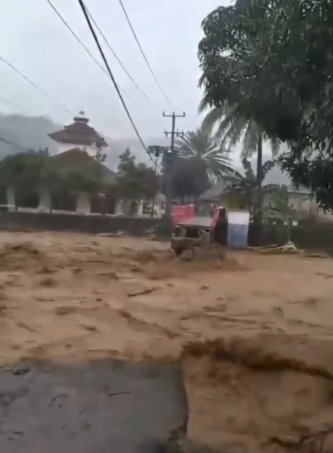 Hujan deras yang mengguyur Kecamatan Cisolok, Kabupaten Sukabumi, pada Minggu (25/10/2025) sore memicu banjir dan longsor di lima desa: Karang Papak, Cisolok, Cikahuripan, Pasir Baru, dan Cigoler. Banjir terjadi sekitar pukul 17.30 WIB akibat meluapnya Sungai Cimarinjung yang merendam puluhan rumah di Kampung Cigoler dan Marinjung Hilir dengan ketinggian air hingga 50 sentimeter. Kawasan wisata Pantai Karang Hawu turut tergenang, sementara tembok penahan tanah di Desa Cikahuripan ambruk dan jalan nasional di Desa Pasir Baru sempat terendam. Menurut Petugas P2BK Cisolok, Andri Firmansyah, 12 rumah warga terdampak banjir dan satu rumah berisiko longsor. Tidak ada korban jiwa, namun pendataan dan pemantauan masih dilakukan oleh tim gabungan dari BPBD, Forkopimcam, TNI, dan Polri. BPBD Sukabumi menyatakan penanganan darurat dan pendataan kerugian tengah berlangsung. Warga diminta tetap waspada karena hujan berintensitas tinggi diperkirakan masih berlanjut dalam beberapa hari ke depan.