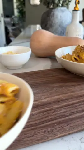 Trader Joe’s Butternut Squash Mac and Cheese // This is my version and dare i say it's even better than the original. (I understand everyone probably says that) LOL buttttt the butternut squash blends right into a velvety cheese sauce and it fills every rigatoni PLUS gets topped with crispy sage breadcrumbs for the perfect bite. every. single. time.  Ingredients 16 oz rigatoni 3 cups diced butternut squash (fresh or frozen; about 1 medium squash) 1 large shallot (roughly chopped) 3 cloves garlic (peeled) 2 tbsp olive oil Salt + pepper (to taste) Sauce Base 1 cups cottage cheese (Good Culture 2%) 1/4 cup Greek yogurt 1 ½ cups milk of choice 1 cup shredded sharp cheddar cheese ½ cup shredded gouda cheese (Trader Joe’s Smoked Gouda or regular gouda) 1/3 cup grated parmesan cheese 2 tbsp nutritional yeast 1 tsp Dijon mustard 1 tsp smoked paprika ¼ tsp nutmeg Crispy Sage Breadcrumbs 2 tbsp salted butter (browned) ½ cup panko breadcrumbs 6-8 fresh sage leaves (finely chopped) Instructions Preheat oven to 400°F. Toss squash, shallot, and garlic with olive oil, salt, and pepper. Roast for 20–25 minutes until tender and caramelized. While the veggies roast, boil pasta until al dente. Drain and set aside, reserving about ½ cup pasta water. Add roasted squash and veggies, cottage cheese, yogurt, milk, cheddar, gouda, parmesan, nutritional yeast, mustard, paprika, and nutmeg to a blender. Blend until smooth and creamy. Taste and adjust salt and pepper. Heat butter in a skillet and sauté on low heat until it’s browned. Add breadcrumbs and sage; toast until golden and fragrant. set aside. Pour sauce into a saucepan over low heat. Warm until just steamy, adding a splash of pasta water to thin if needed. I didn’t need it personally, but it’s good to save the pasta water just incase. Stir in the cooked pasta until evenly coated. Spoon the mac and cheese into bowls and sprinkle with sage breadcrumbs and enjoy! #butternutsquash #traderjoes #fallcooking #macandcheese 