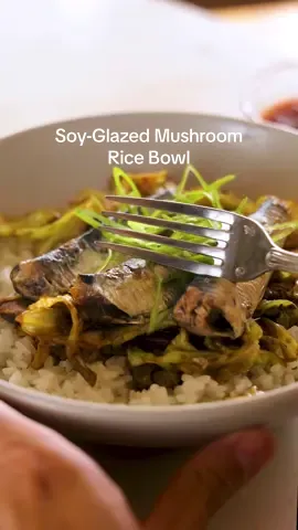 Here's how to make this Soy-Glazed Mushroom Rice Bowl: • 5 teaspoons olive oil, divided • ½ pound cremini mushrooms, sliced • 1 medium (1½-pound) Napa or green cabbage, cored and chopped • 3 large garlic cloves, smashed • 3 tablespoons soy sauce • 1½ teaspoons chile-garlic sauce (preferably Huy Fong), plus more for serving if desired • 1 teaspoon toasted sesame oil • Cooked white rice, for serving • 3 (4-ounce) cans boneless sardines in oil (skin-on or skinless), optional • Thinly sliced scallions, for serving In a large cast-iron skillet over medium-high heat, warm up 3 teaspoons of olive oil. Once oil is loose and shimmering, about 1 minute, add the mushrooms and stir sparingly, leaving the mushrooms largely undisturbed. Cook until the mushrooms have softened and reduced down slightly in size, about 5 minutes. Stir in the chopped cabbage and the remaining 2 teaspoons of olive oil, cover and cook, stirring occasionally. After 2 to 3 minutes, lower the heat to medium and stir in the garlic, soy sauce, chile-garlic sauce and sesame oil. Cover and cook for another 15 minutes, stirring as needed, until the cabbage is almost caramelized. Serve the cabbage-mushroom mixture over rice. Top with sardines, if you like, and scallions. Serve with additional chile-garlic sauce. Enjoy immediately or store in the fridge in an airtight container for 2 to 3 days.