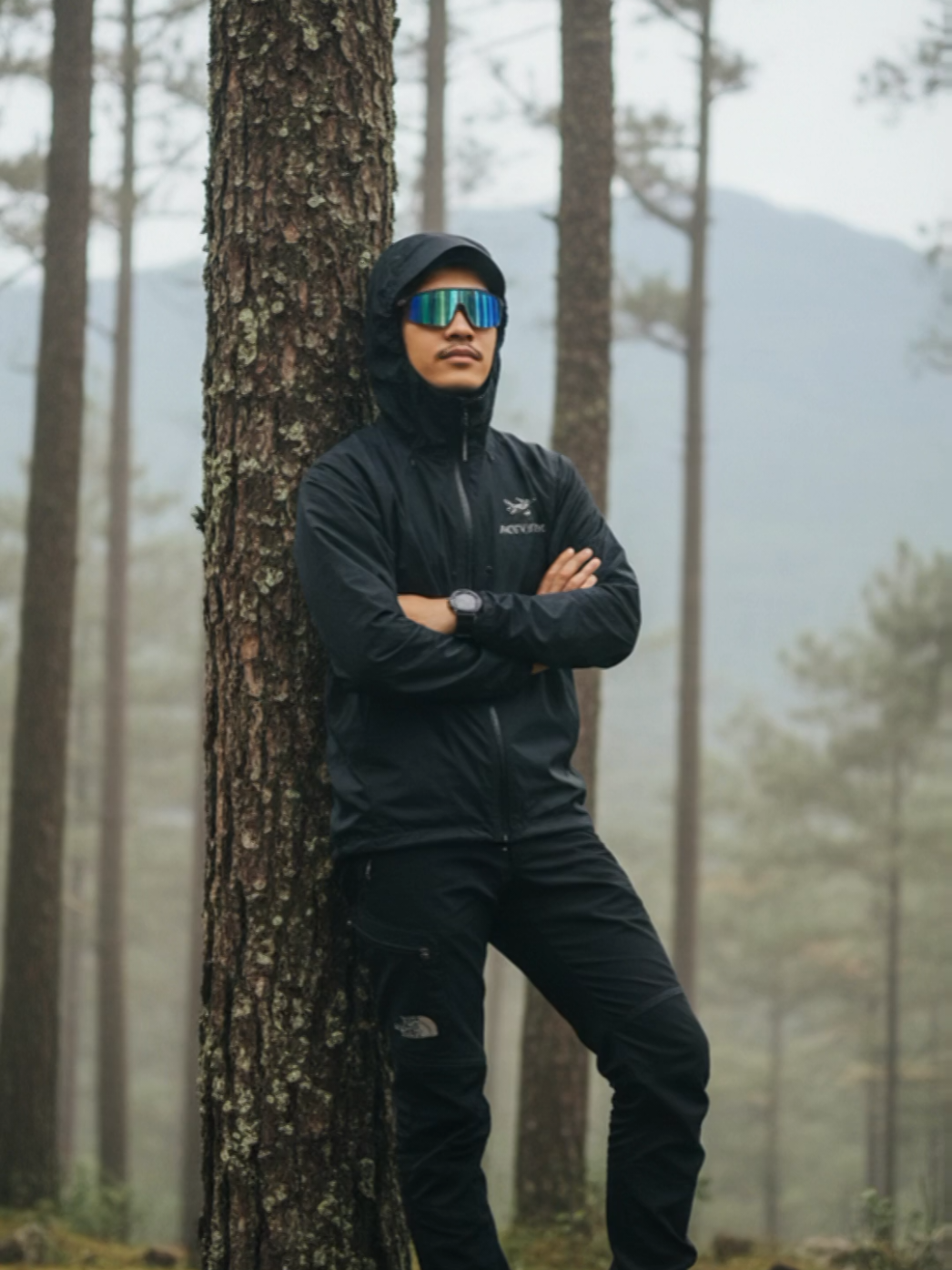 Promosi prompt: Buat foto ini tanpa merubah wajah asli. Seorang pria berumur sekitar 27 tahun, dengan wajah asli yang sama seperti pada foto referensi (jangan diubah atau diganti), sedang berpose di area hutan pinus dengan latar belakang gunung yang samar dan sedikit buram, menciptakan suasana alam yang lembap, dingin, dan misterius. Detail Subjek dan Outfit: Jaket: Pria mengenakan jaket Arc'teryx Beta AR berwarna hitam dengan bahan tahan angin dan air, tampak logo putih kecil khas Arc'teryx di dada kiri. Jaket terlihat bertekstur matte dengan resleting silver mengilap di bagian depan dan saku. Tudung jaket ditarik ke atas menutupi sebagian kepala dan memberi kesan petualangan serta keren. Celana: Ia mengenakan The North Face softshell pants warna hitam dengan detail patch abu gelap di bagian lutut dan kantong sisi paha, berpotongan loose fit khas gaya outdoor modern. Sepatu: Sepasang Eiger Mountaineering Boots warna coklat tua dengan sol tebal abu gelap, detail jahitan kokoh dan desain tangguh khas sepatu gunung, terlihat kotor sedikit karena tanah lembap. Aksesoris: Kacamata Oakley Radar EV Path dengan lensa mirror biru kekuningan, memantulkan cahaya dari langit di sekitar. Jam tangan Garmin Forerunner 965 hitam di pergelangan tangan kiri, dengan layar menampilkan data detak jantung dan waktu aktivitas. Pose dan Ekspresi: Pria tersebut berdiri tegak diantara pepohonan pinus dengan satu tangan menujuk ke kamera dan satu tangan berada di saku celana dengan ekspresi wajah tenang namun tegas. Pandangan mata sedikit tertutup visor, memberi kesan cool, tangguh, dan misterius. Latar Belakang dan Suasana: Latar belakang memperlihatkan hutan pinus tinggi dengan kabut tipis, tanah berlumut dan batuan lembap di bawah. Gunung di kejauhan tampak samar dalam kabut abu kebiruan. Pencahayaan alami dari cahaya pagi atau sore yang lembut, memperkuat nuansa petualangan dan kontras antara pakaian hitam dengan alam sekitar. Kesan keseluruhan: Foto ini terasa realistis, bergaya gorpcore outdoor, maskulin, misterius, dan sinematik. Warna dominan hitam dan abu menciptakan suasana petualangan yang dingin dan elegan. Jangan ubah wajahnya harus mirip foto referensi 100%. #Gemini #capcut #gorpcore #fyppppppppppppppppppppppp #trand 