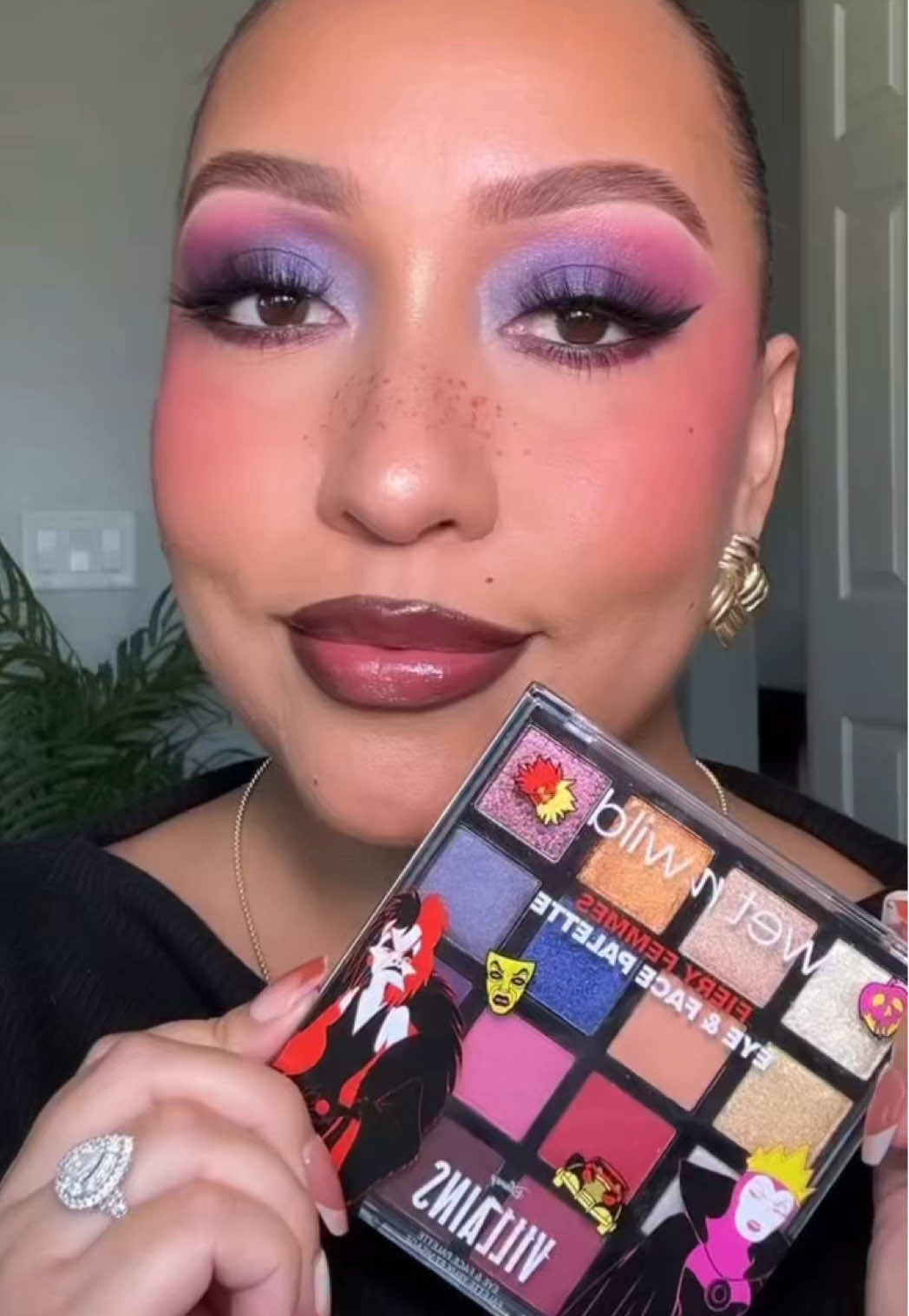Isn't @Joanna Rodriguez ⁠ stunning in our Disney Villains collection? We're obsessed with this bold & colorful look 💜⁠ ⁠ Featuring: ⁠ 🖤 Fiery Femmes Eye & Face Palette in Unleashed⁠ 🐾 We Won't Bite Cream Blush in Wretched⁠ 👑 Pick Your Vice Plumping Lip Gloss in Evil Witch⁠ ⁠ Shop the entire wet n wild Disney Villains collection @walmart (online & in-store) @walgreens @ultabeauty (online only) @amazon  