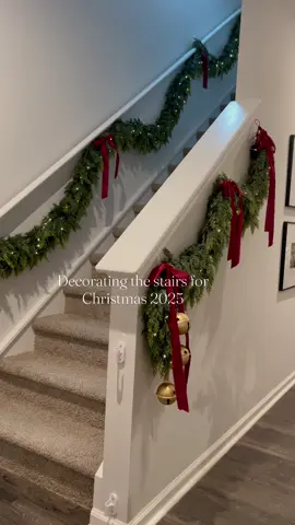 Decorating the staircase of my home for Christmas 2025. I love how it turned out. I’m using cedar garlands and beautiful burgundy bows. And of course twinkle lights and bells.  Link in bio #christmas2025 #nostalgicchristmas #traditionalchristmas #cedargarland #stairs 