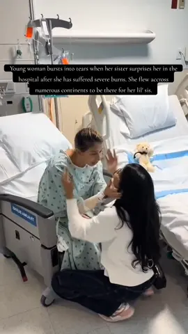 Young woman bursts into tears when her sister surprises her in the hospital after she has suffered severe burns. She flew accross numerous continents to be there for her lil' sis.