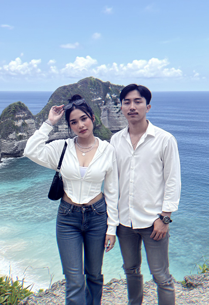 prompt Gemini ai di nusa penida Bali bareng pasangan terbaru. Buat gambar potret pria dan wanita wanita (orang di foto yang diunggah), pertahankan wajahnya 10000% sama dengan foto yang diunggah, dengan mata, alis, hidung, dan mulut dipertahankan 1000%. Rambut pria sama seperti yang di foto dan wanita mengenakan Detail Karakter Pakaian Atasan: Cropped Zip-Up Hoodie Jaket Tudung Ritsleting Pendek) tambahkan inner baju berwarna putih agar tidak terlihat leher dan pusar. Warna: Putih. Bentuk/Panjang: Model oversize setinggi pinggang, menonjolkan bagian pinggang dan perut. Lengan: Lengan panjang. Leher/Atas: Memiliki tudung (hoodie) dan ritsleting depan yang diturunkan, membentuk leher V yang dalam. Desain: Ketatkan (body-hugging), menonjolkan lekuk tubuh. Mungkin memiliki detail jahitan Atau garis-garis yang membantu atasan terlihat lebih pas seperti korset di area tubuh. Bawahan: Celana Jeans Jenis: Celana jeans longgar (loose-fit) dengan potongan kaki lebar (flared), mengikuti tren Y2K yang populer. Bentuk: Bagian kaki celana sangat lebar, mulai dari paha hingga ujung kaki. Warna/Warna Luntur: Warna luntur (wash) biru tua/medium dengan efek luntur yang terlihat alami. Aksesori Kalung: Mengenakan kalung berlapis (layered) yang menonjolkan logam perak. Perhiasan: Beberapa gelang dan cincin di jari-jari dan pergelangan tangan. Tas: Tas selempang bahu (shoulder bag) berwarna hitam model Baguette. Paku Keling/Kancing: Logam. Sepatu: Sepatu olahraga/sneakers. Warna: Putih/Perak. Detail Tata Rias, Rambut, Kamera, dan Pencahayaan 59 Tata Rias (Makeup) Riasan: Nuansa alami (natural tone) yang memberikan kesan manis. Wanita memiliki rambut yg di ikat asal dan sedikit berantakan sehingga anak rambut dan akar dasarnya ny menutupi wajahnya yang memberi kesan manis dan imut . Kulit: Putih, mulus, dan cerah. Pipi: Perona pipi (blush on) warna oranye kemeraha Pria mengenakan kameja putih, celana abu² dengan sobekan dan sepatu sneakers putih sedang berdiri dengan prose santai di tepi tebing batu abu-abu di Kelingking Beach, Nusa Penida, Bali. Di kejauhan, terdapat formasi tebing/pulau batu kapur berwarna hijau yang menyerupai kepala dinosaurus atau jari kelingking, menjadi ikon dari pantai tersebut. Langit cerah berwarna biru dengan awan cumulus putih yang tersebar. Air laut di sekitar tebing Kelingking berwarna pirus muda yang bening, semakin jauh menjadi biru tua pekat.,  . Seluruh adegan memiliki pencahayaan alami yang terang, dengan detail yang tajam dan jelas di semua bagian gambar, tanpa efek bokeh atau blur kedalaman. Posenya pria dan wanita  berdiri santai  ,mendongak melihat ke kamera dari atas, wanita sedikit memegang kacamata agar matanya terlihat. Dan sedikit menyender ke bahu pria  Ekspresi Wajah: Wajah terlihat tenang, sedikit tersenyum tapi menawan.  Gestur Tangan: Dia berdiri dan satu tangan memegang kacamata yang ada di atas kepala. JANGAN ganti wajah orang, pertahankan wajah orang yang sama 10000% dengan kejernihan tingkat HD. #prompt #geminiai #nusapenida #aitrend #fyp 