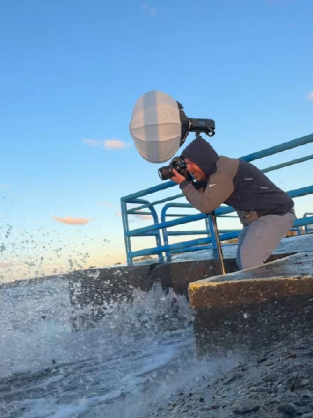 Photographer and client brave monster waves for this pier photoshoot.