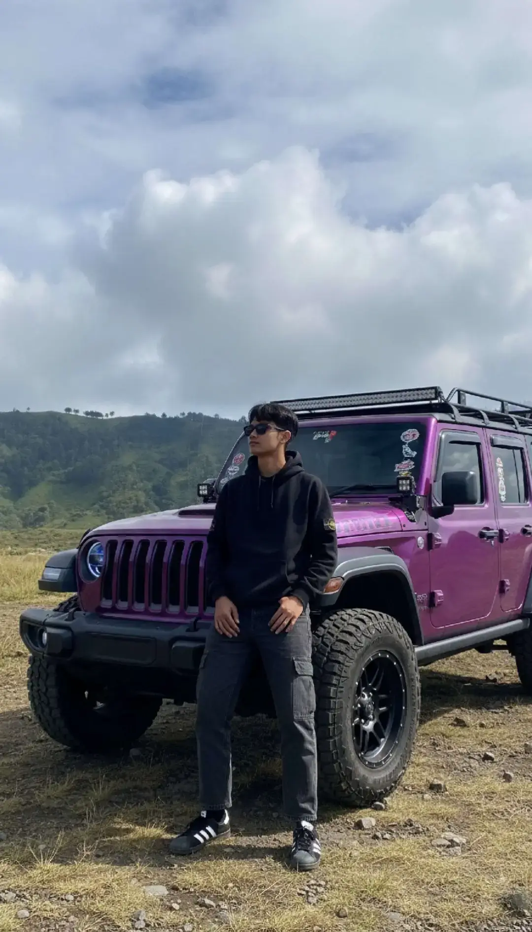 TUTORIAL?? CAPTION‼️ 1. Buka google/apk gemini di hp kalian 2. Masukan photo wajah kalian dan pastekan  prompt:👇🏻 Coba buatkan sebuah foto full-body yang cerah dan mendalam dari subjek pria tersebut, menampilkan seorang pria muda dengan gaya urban outdoor yang santai, berdiri dengan pose side profile yang kontemplatif di tengah padang rumput yang luas di kaki sebuah gunung. Subjek mengenakan hoodie hitam pekat dengan emblem kecil di lengan, celana kargo abu-abu gelap, dan sepatu sneakers hitam-putih klasik (mirip Adidas Samba), serta kacamata hitam yang menutupi pandangannya. Kedua tangannya dimasukkan ke dalam saku hoodie, menciptakan siluet yang rileks namun penuh gaya. Ia berdiri di atas tanah kering yang berbatu dan berumput kuning kecoklatan yang jarang, yang menjadi jembatan menuju latar belakang yang spektakuler. Latar belakang didominasi oleh lereng gunung yang sangat curam dan megah, tertutup rapat oleh vegetasi hijau segar dan rimbun, dengan alur-alur erosi vertikal yang dramatis. Di kejauhan di kaki gunung, terlihat beberapa tenda kemah kecil berwarna-warni, menandakan kehadiran manusia di lanskap liar ini. Langit di atas adalah biru cerah yang luas dan jernih, dihiasi oleh awan putih tipis yang bergerak perlahan. Pencahayaan alami yang kuat dari sinar matahari langsung pada hari yang cerah menciptakan kontras yang tajam dan bayangan yang jelas, menonjolkan tekstur detail pada pakaian, wajah, dan setiap detail lanskap. Foto ini memancarkan suasana petualangan yang cerah, ketenangan, dan kekaguman terhadap keindahan alam pegunungan yang luas dan menawan, dengan sentuhan gaya personal yang kuat. 3. Tunggu hasilnya 4. Kalo sudah sesuai Download nahh sekarang kamu udh ngga bakal dihina lagi Bree👍🏻 #prompt  #geminiai #googlegemini #fyp #bromo 