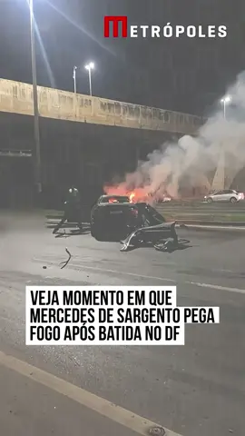 Novas imagens obtidas pelo Metrópoles mostram o exato momento em que a Mercedes-Benz do terceiro-sargento da #PolíciaMilitar de #Goiás (PMGO), Fernando Jansen Silva Araújo, de 42 anos, pega fogo na Estrada Parque Indústria e Abastecimento (EPIA), em frente ao ParkShopping, no Guará. Um homem que passava no local filmou a cena do acidente minutos depois da colisão, quando o veículo ainda não estava completamente desfigurado. Populares que passavam no local prestaram os primeiros socorros. O policial da PMGO Fernando Jansen perdeu a vida após o carro em que estava colidir violentamente contra o pilar de sustentação do viaduto de acesso ao Guará. No veículo também estava uma mulher, a técnica em enfermagem Simara de Almeida Cavalcanti Monteiro, de 45 anos, que sobreviveu, mas sofreu múltiplas fraturas e foi encaminhada em estado grave a uma unidade de saúde da região. Segundo informações do Corpo de Bombeiros Militar do Distrito Federal (CBMDF), o acidente ocorreu por volta das 4h30 da madrugada. Cinco viaturas de socorro foram mobilizadas. Ao chegarem ao local, as equipes encontraram o Mercedes-Benz preto em chamas após o forte impacto. #tiktoknotícias