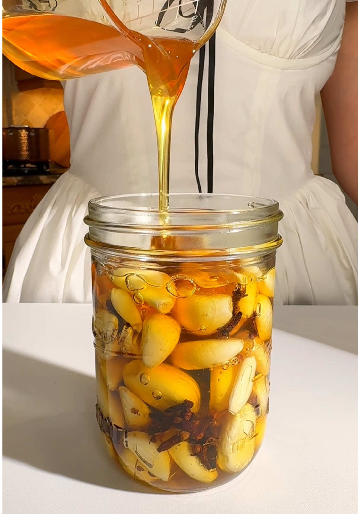 My Grandma’s Ancient Secret Honey Garlic Elixir (Natural Immunity & Cold Remedy) 🛒 Ingredients (for 16 oz / 475 ml jar)  • 1½ cups (180 g) peeled garlic cloves 🧄  • 2 tbsp (12 g) whole cloves 🌿  • Raw honey — enough to fill to the top, leaving ½ inch (1–2 cm) of space 🐝 👩‍🍳 Instructions: 1️⃣ Sterilize the jar:  • Place the empty glass jar (without lid) in the oven at 250°F (120°C) for 10 minutes, or boil it in water for 5 minutes.  • Let it cool completely before use. 2️⃣ Prepare the garlic:  • Peel garlic cloves and make sure they’re clean, dry, and free from any moisture — this prevents mold. 3️⃣ Assemble the jar:  • Layer garlic and cloves alternately inside the sterilized jar.  • Slowly pour raw honey over the layers, moving the jar slightly to release any air pockets.  • Fill up to the top, leaving a bit of space (about ½ inch) for gases to expand.  • Place a small piece of parchment paper between the lid and jar to prevent metal contact with honey (which can cause corrosion). 4️⃣ Fermentation process:  • Loosely close the lid — don’t seal it airtight.  • Keep the jar at room temperature (68–75°F / 20–24°C) for 3–5 days.  • Open daily to “burp” it — this releases gases naturally formed by fermentation.  • Stir or tilt the jar gently once a day to coat all garlic with honey. 5️⃣ Storage:  • After 3–5 days, close the lid tightly and move the jar to the refrigerator.  • It will continue to ferment slowly in the fridge and deepen in flavor over time.  • Shelf life: up to 3 months refrigerated, if kept clean and dry. 6️⃣ How to use:  • Enjoy 1 garlic clove or 1 tsp of honey daily — great in tea, warm water, or directly on a spoon. 🧠 Benefits of This Elixir  • Boosts immune system and helps fight colds & flu naturally 🌿  • Supports respiratory health and eases sore throat 💨  • Rich in antioxidants and antimicrobial compounds 🦠  • Improves gut health through natural fermentation 🌱  • Balances energy levels and promotes natural detoxification 🌸 🌟 Nutrition (Per 1 tbsp) ~64 kcal | ~0.1 g Protein | ~17 g Carbs | ~0 g Fat