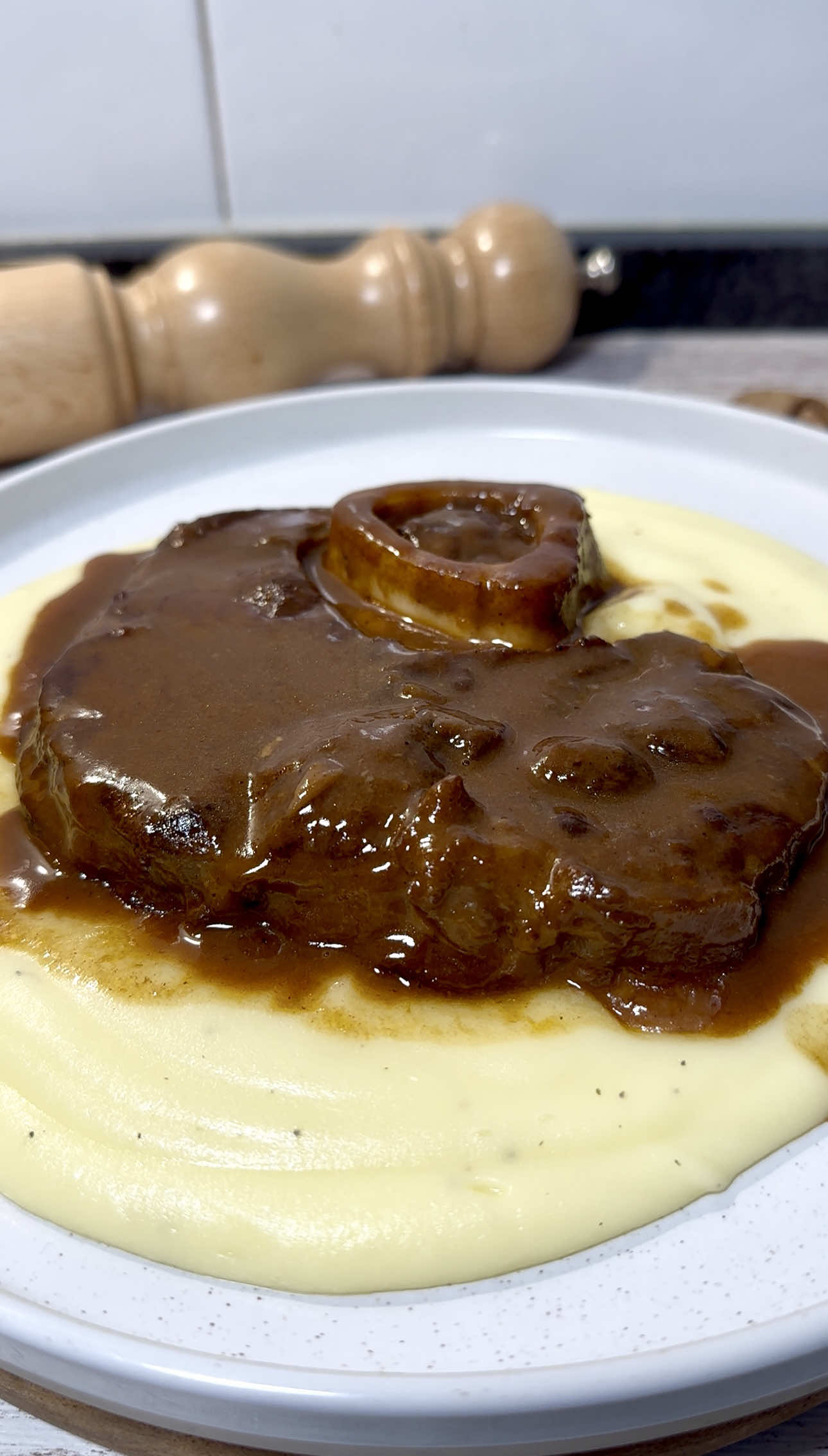 Ossobuco de ternera en su salsa 🍖🍷 Hoy cocinamos un plato que me encanta. Una carne sabrosa, tierna y con una salsa para mojar media barra de pan… ¡no os la perdáis!  📝 INGREDIENTES (3 personas): ▪️1kg de ossobuco de ternera  ▪️1 vaso de vino tinto  ▪️≈800ml de  de caldo o agua (hasta cubrir) ▪️1 zanahoria  ▪️1 cebolla ▪️1/2 puerro ▪️1 rama de apio  ▪️1 cabeza de ajos ▪️2 cdta tomate concentrado  ▪️1 cucharada sopera de harina de trigo  ▪️Aceite de oliva  ▪️Sal y pimienta al gusto  ▪️Laurel, romero y tomillo (para aromatizar) 👨🏻‍🍳 PASO A PASO: 1️⃣ Salpimentamos el ossobuco de ternera y doramos en un cazuela con un buen chorro de aceite de oliva, unos 3-4 minutos por lado, hasta que esté bien sellado. 2️⃣ En la misma cazuela añadimos la cebolla, puerro, apio y zanahoria picada. Le damos un par de vueltas y añadimos también la cabeza de ajos, cortada a la mitad. Rehogamos unos 15 minutos a fuego medio, removiendo cada poco y reincorporamos el ossobuco.  3️⃣ Desglasamos con el vino tinto, dejamos reducir unos minutos. Vertemos caldo hasta cubrir el ossobuco, añadimos los aromáticos (laurel, tomillo, romero, etc…) y hervimos a fuego suave con olla tapada durante 2 horas.  4️⃣ Una vez la carne esté tierna, retiramos con mucho cuidado y colamos la salsa, presionando bien las hortalizas en un colador para que suelten todo el jugo. Devolvemos el líquido a la cazuela y reducimos unos 10 minutos a fuego alto.  5️⃣ Añadimos de nuevo el ossobuco y cocinamos media hora más junto con la salsa, a fuego suave, hasta que esté súper tierno y la salsa haya tomado textura y color. Servimos con puré de patatas y… ¡a disfrutar!  . . . . #cocinaentiktok #recetas #cocinatradicional #guiso #recetafacil 