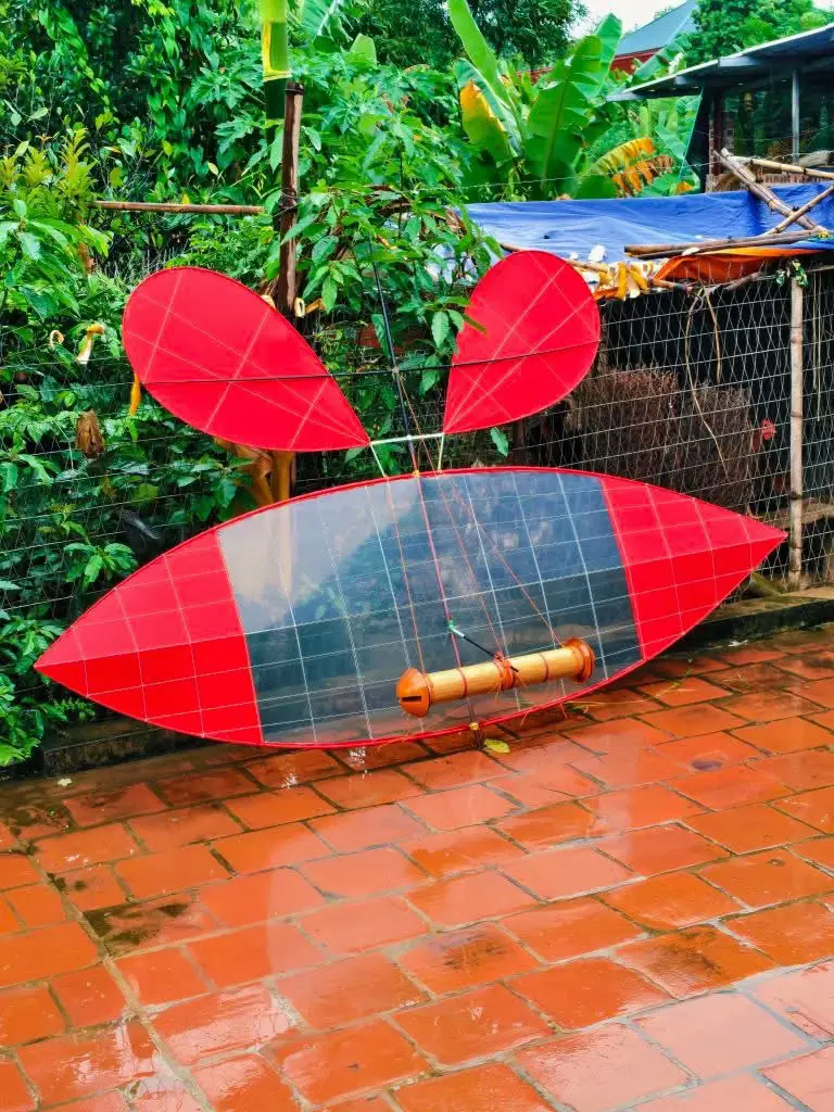 Anh em nhìn xem! Chiếc diều Tân Yên này có bị 'khê' không? Mình thấy nó giống con mắt nào đó đang 'trinh mãi' không được! Cắm ở đây chắc lỗ mấy đêm gió 'phê' lắm nhỉ? Anh em nào 'sỹ' đủ mạnh thì vào 'gánh' Totem con mắt này xuống giùm cái! Ngại gì mà không nhận hàng? 😉