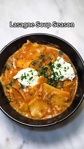 It’s officially lasagne soup season and I’m obsesseddd  Lasagna Soup (Vibes Edition because I don’t measure anything) 	1.In a large pot, sauté diced onions and minced garlic until fragrant. 	2.Add ground beef and season with Italian seasoning, Tony’s, onion powder, and other spices of choice. I use whatever I feel like lol Cook until browned. 	3.Stir in tomato paste and mix well. 	4.Add a full jar of pasta sauce and a carton of chicken broth. Bring to a boil. 	5.Break up a box of lasagna noodles and add to the pot. Boil until noodles are almost tender. 	6.About 5 minutes before done, stir in Parmesan cheese, parsley, and a splash of heavy cream. Reduce heat and simmer for 5 minutes. 	7.In a separate bowl, mix ricotta, parsley, Parmesan, and a pinch of seasoning. 	8.Serve the soup topped with a spoonful of the ricotta mixture and enjoy! #soupseason #lasagna #lasagnasoup #souprecipe #soup 